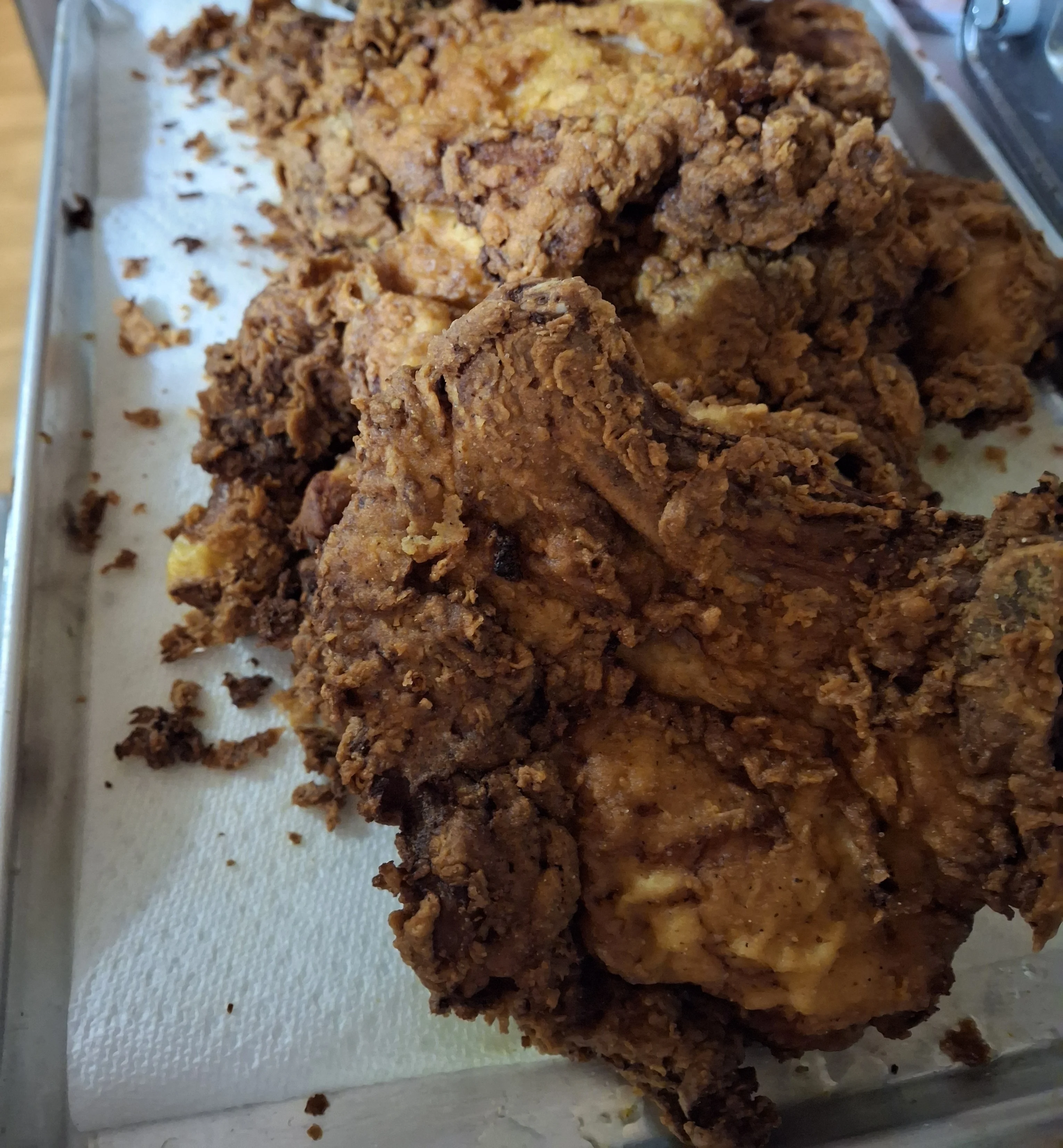 A close-up of crispy fried chicken pieces resting on a paper towel.