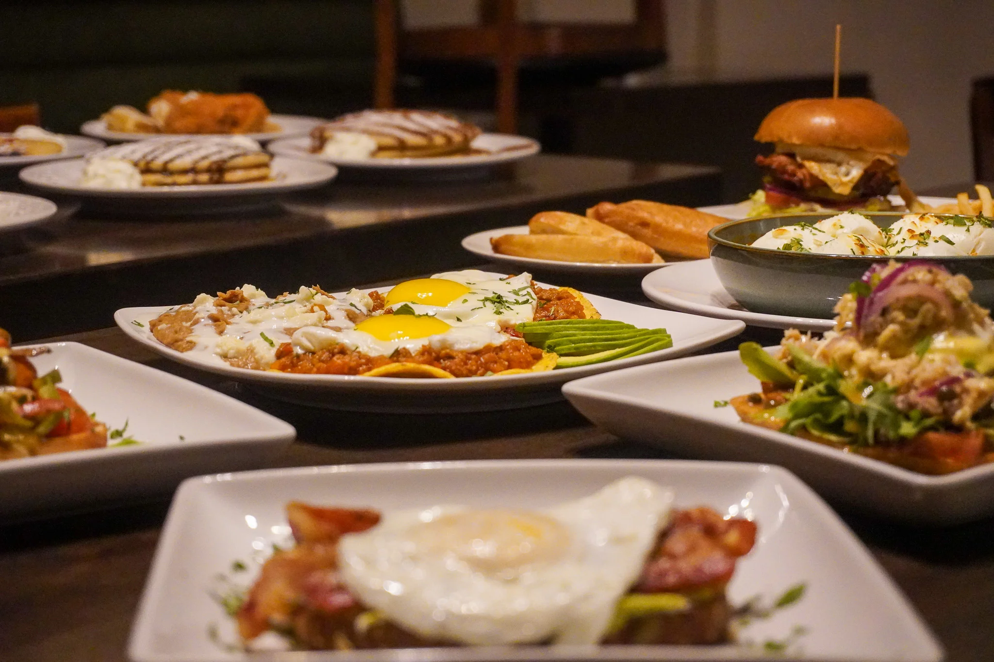 Colorful Mexican breakfast spread with huevos rancheros and various dishes
