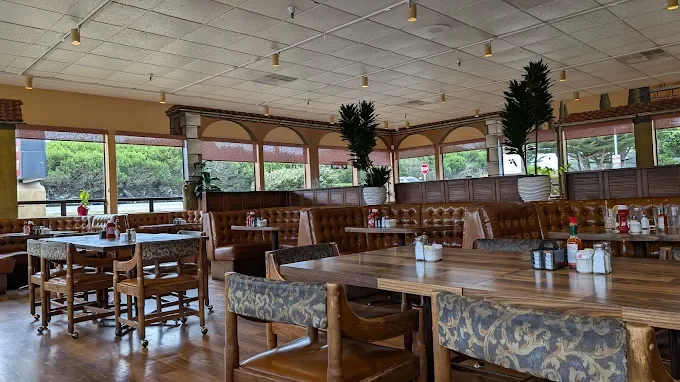 Cozy restaurant interior with wooden tables and large windows