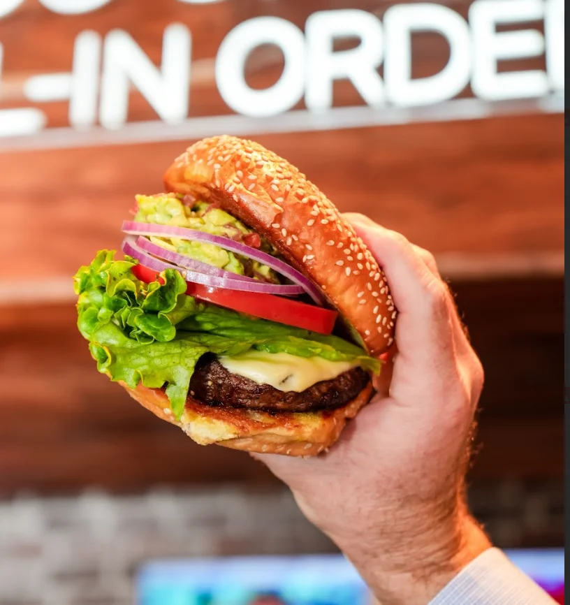 Delicious Hamburger with lettuce tomato, red onion, guacamole and pepperjack cheese.