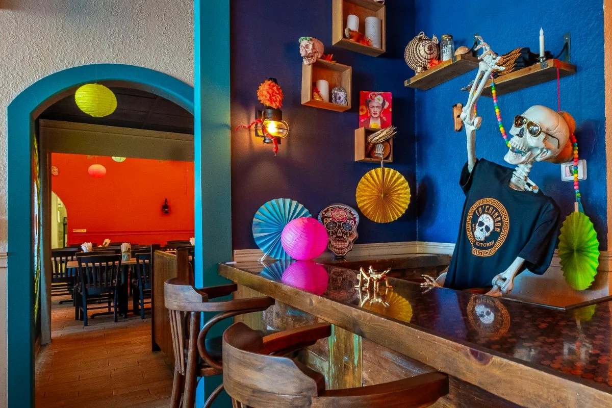 Colorful restaurant interior with festive decor and a skeleton figure