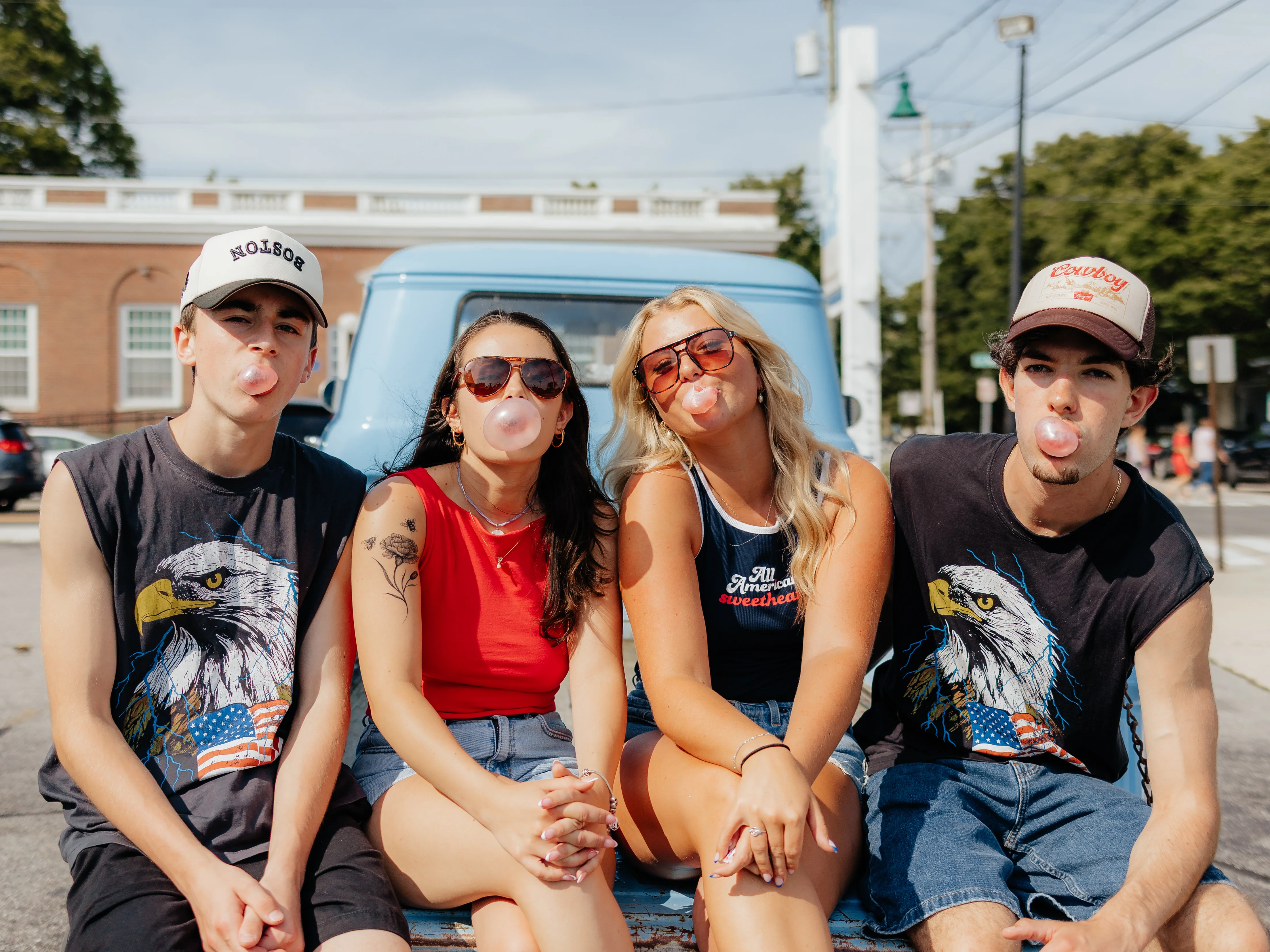 Group of friends blowing bubble gum in summer attire