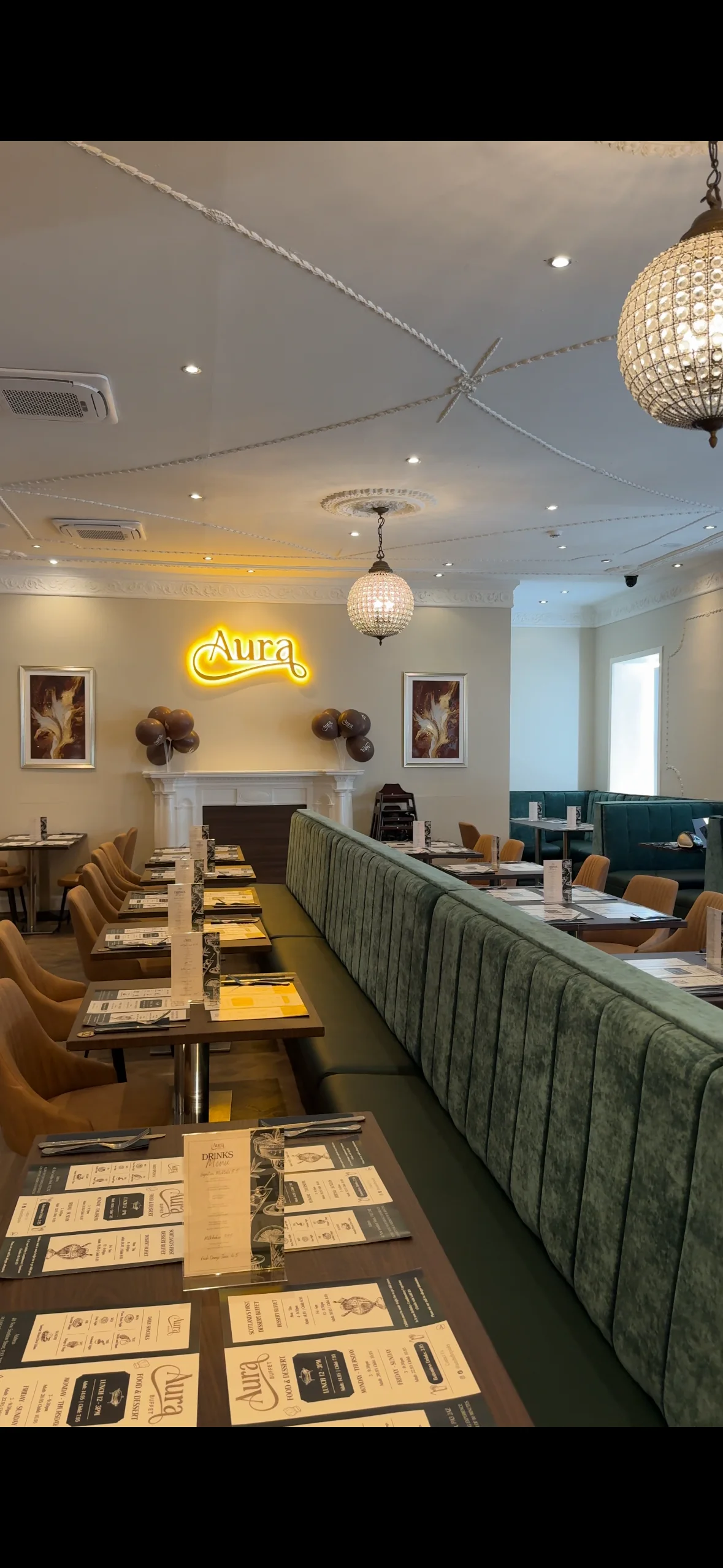 Interior of Aura restaurant with seating and decorative lighting.