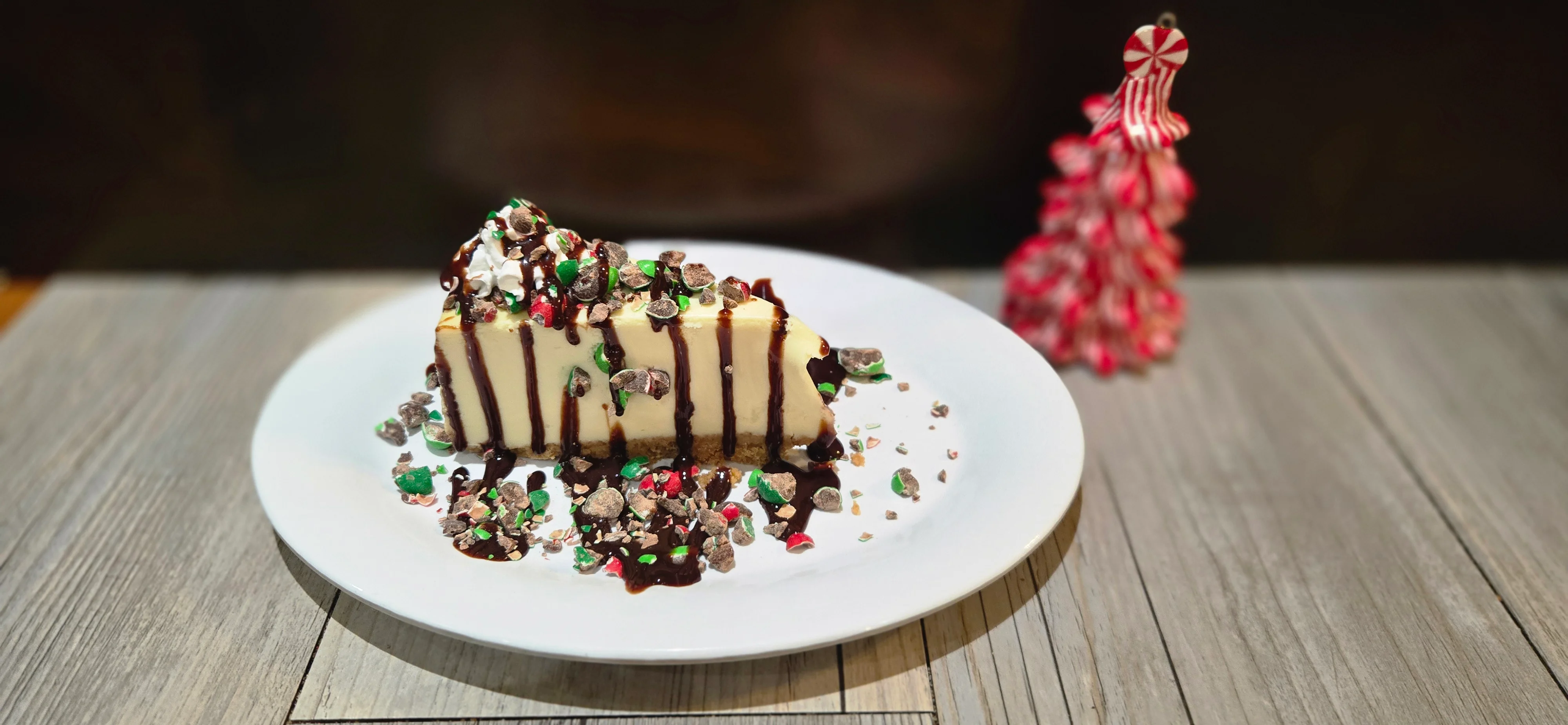 Festive cheesecake slice with chocolate drizzle and holiday toppings