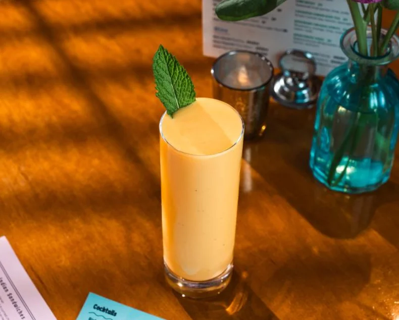 Refreshing mango lassi topped with mint leaves