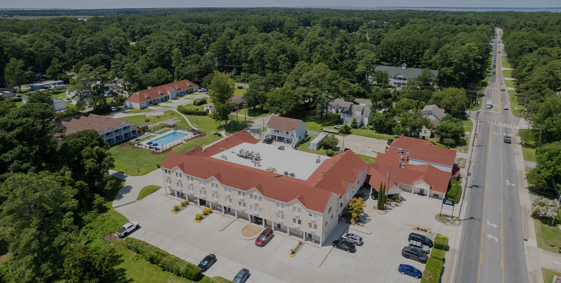 Aerial view of Hotel Manteo on Roanoke Island, with Firetender on the ground floor and the outdoor pool behind