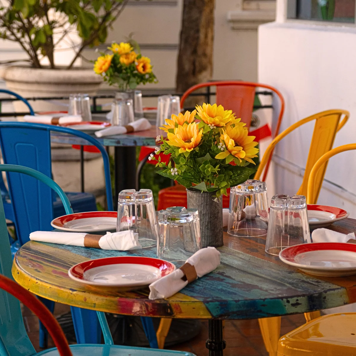 Colorful outdoor dining setup with flowers and tableware