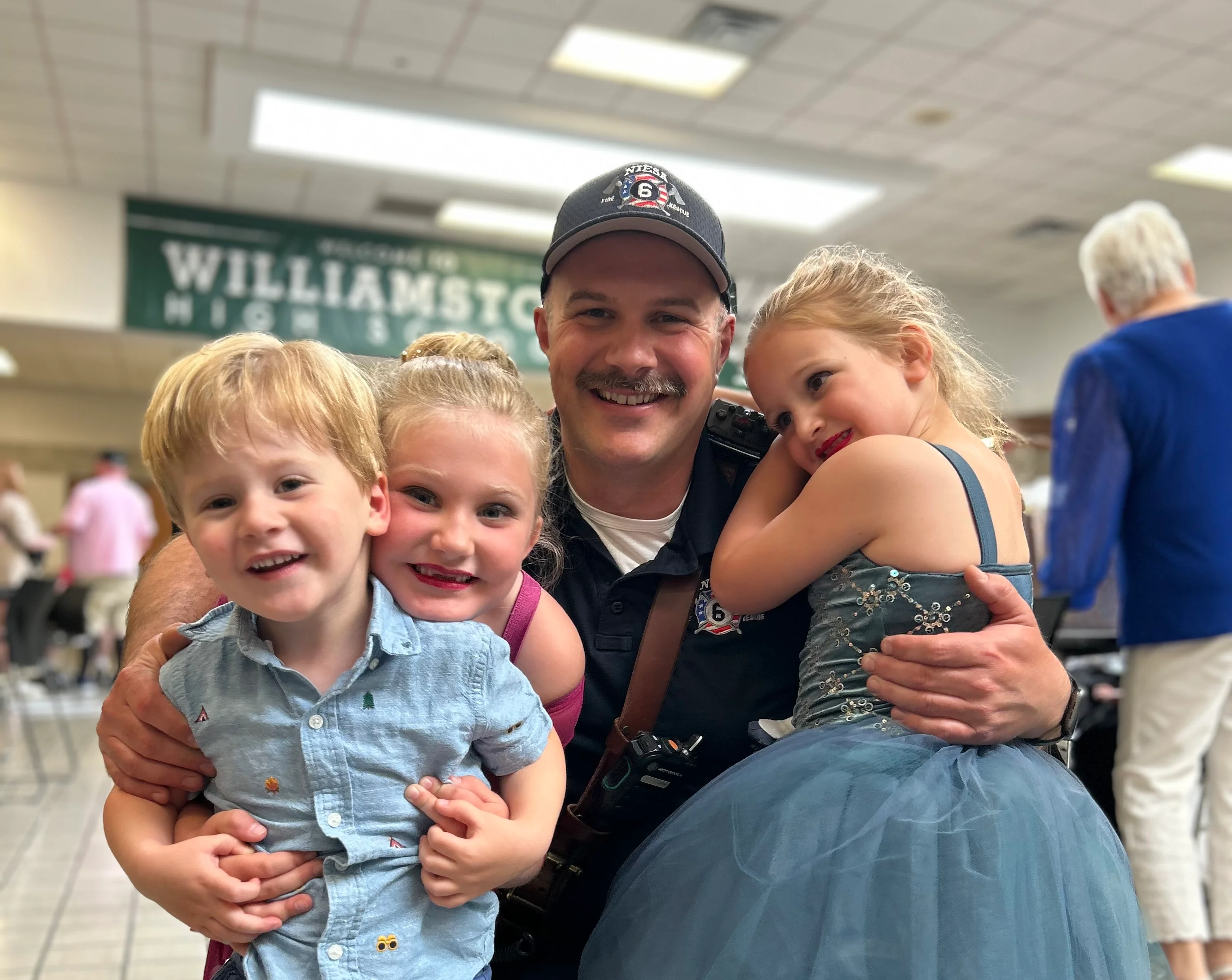 Smiling man with children at a dance event