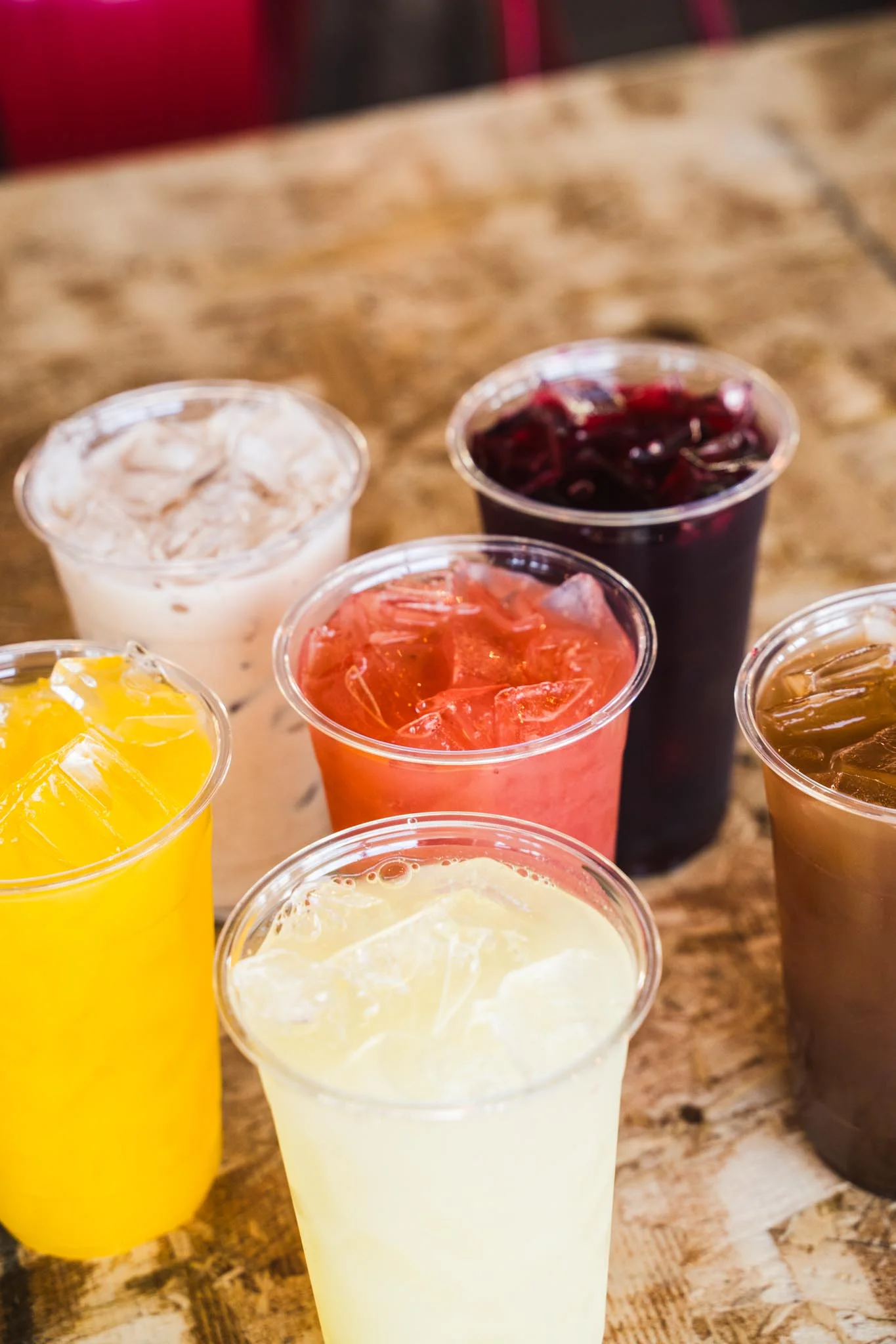 A vibrant red drink with a spicy rim, served in a clear cup.