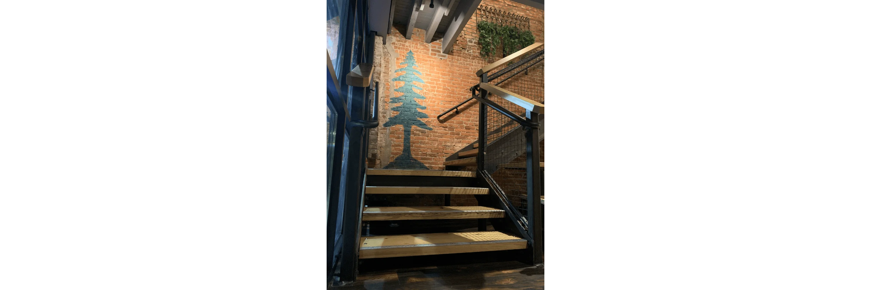 Stylish staircase with wooden steps and brick wall decor