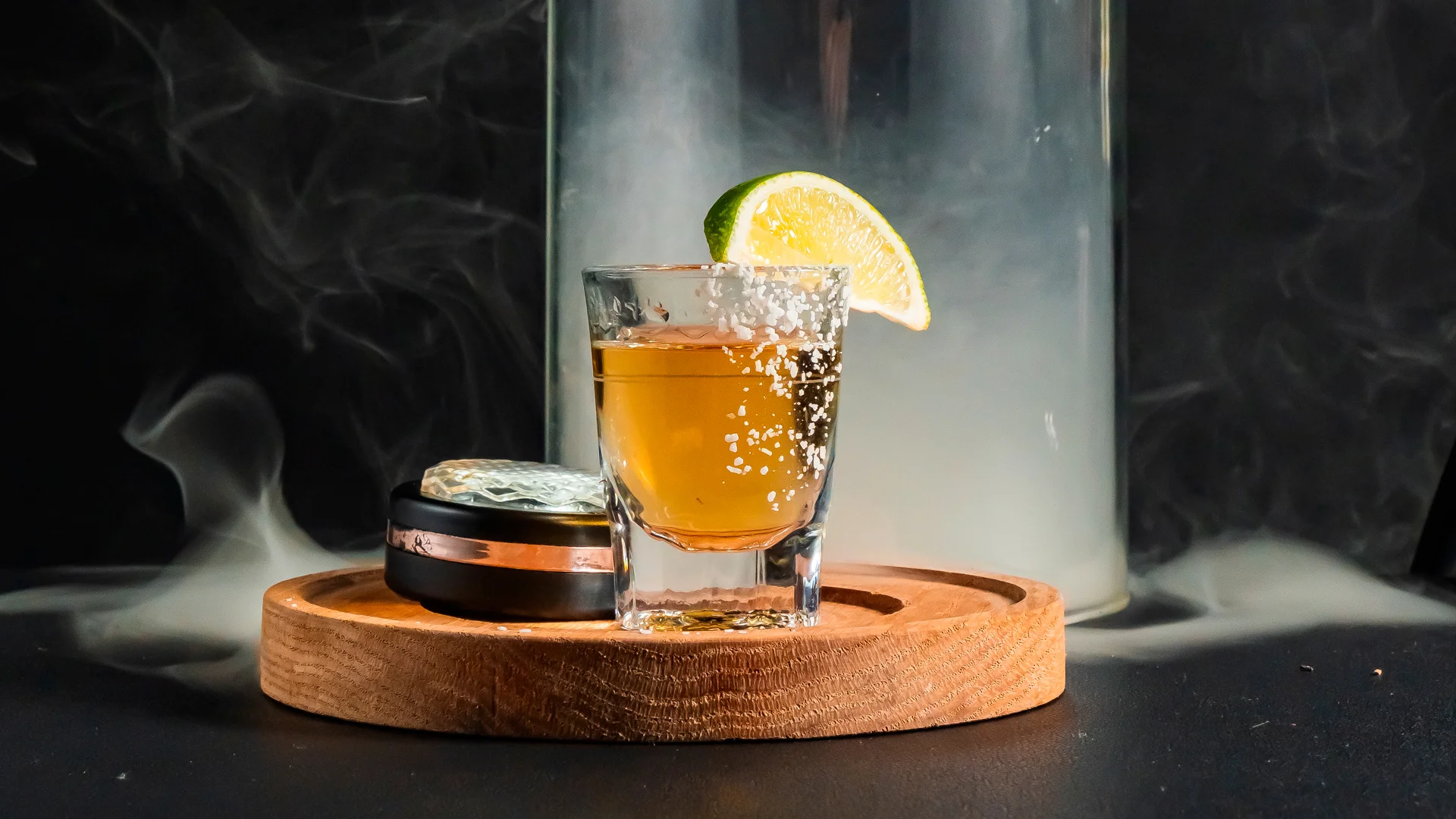 Tequila shot with lime and salt on a wooden platter