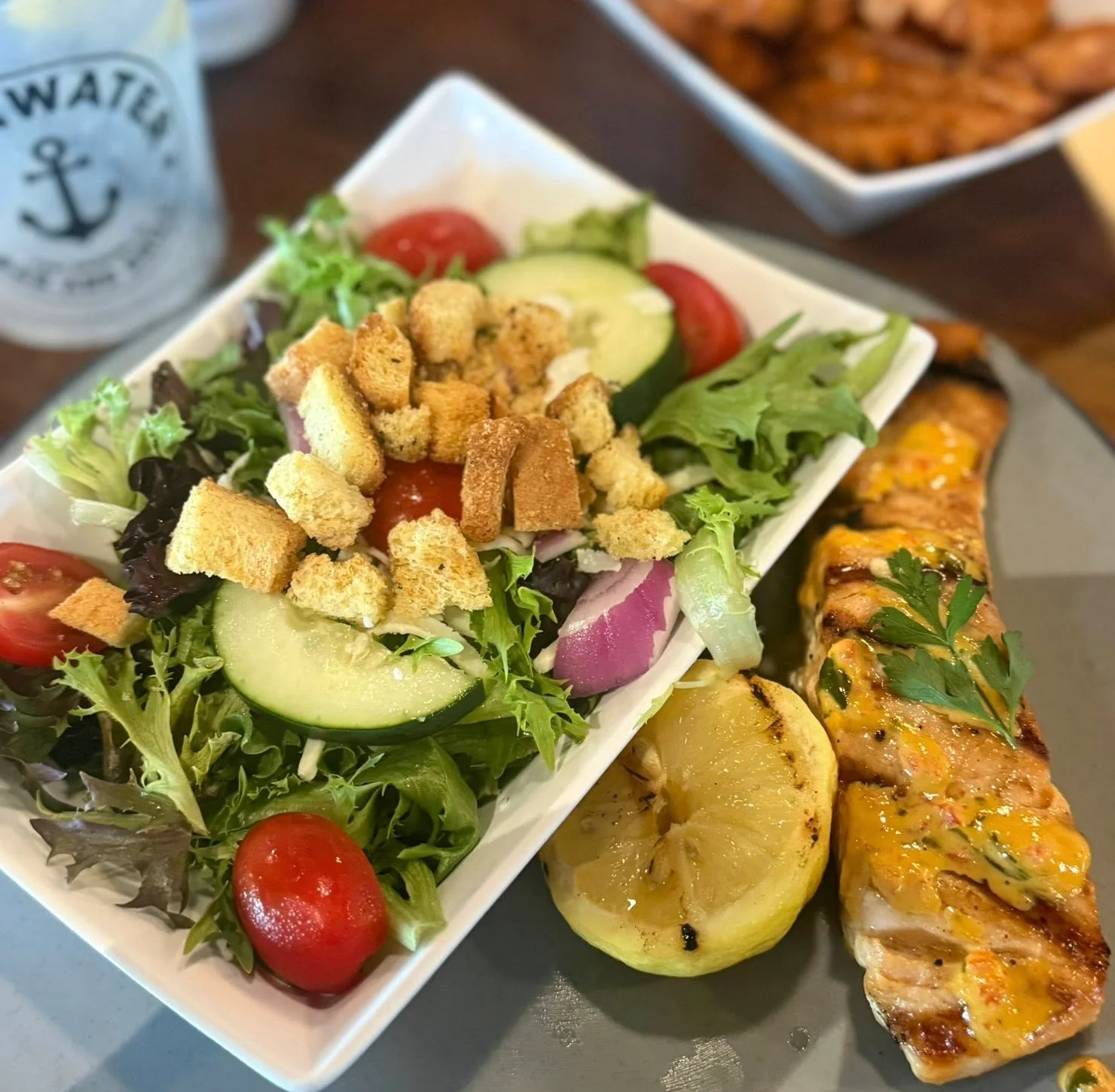 Grilled salmon with garden salad and lemon wedge