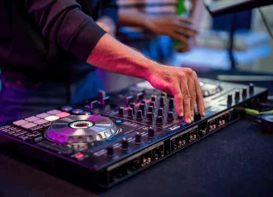 Close-up of a young male artist performing as a DJ at an event.