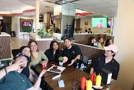 Group of friends enjoying a meal in a vibrant restaurant setting