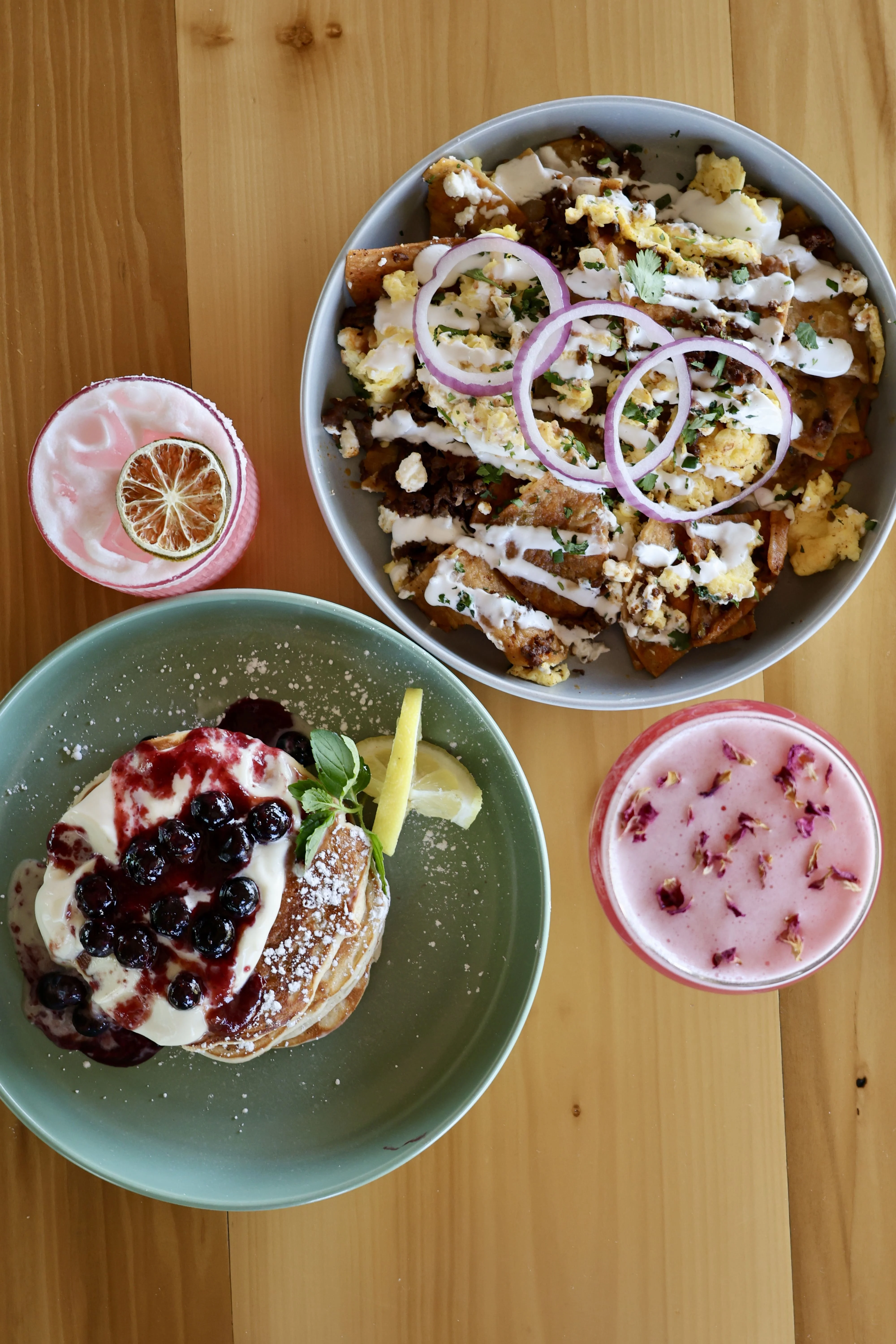 Loaded nachos and blueberry pancakes with drinks