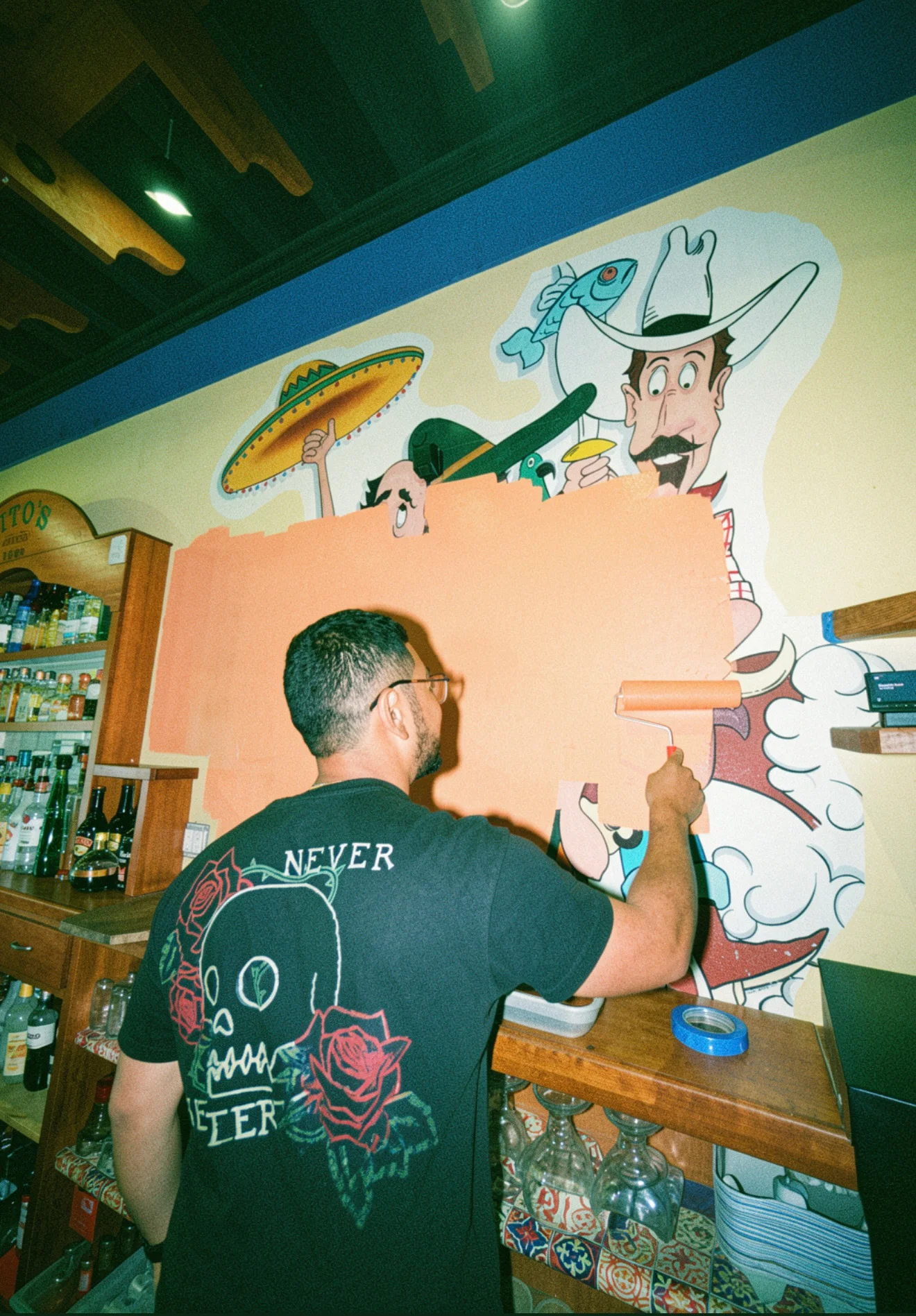 Artist painting a vibrant mural in a lively restaurant interior