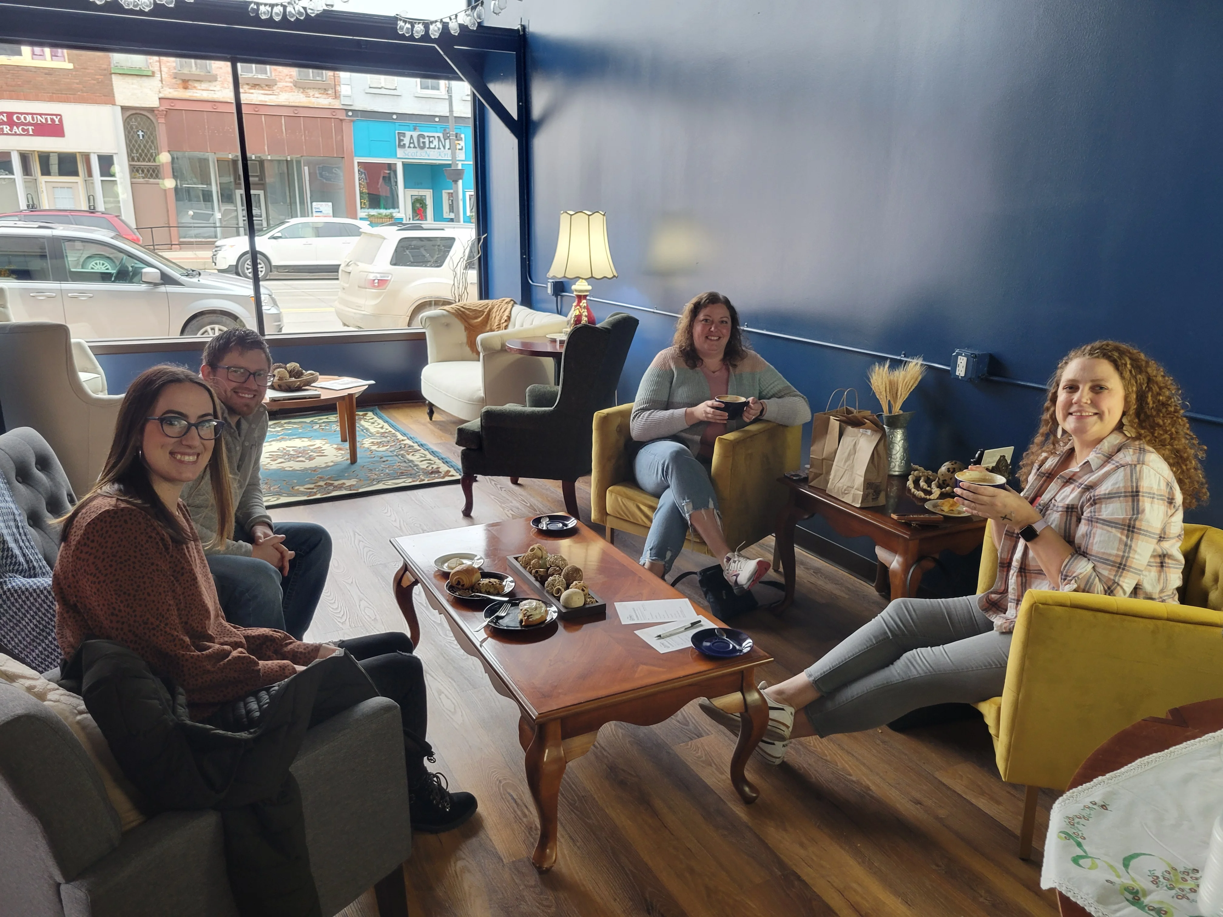 Cozy café interior with friends enjoying coffee and pastries