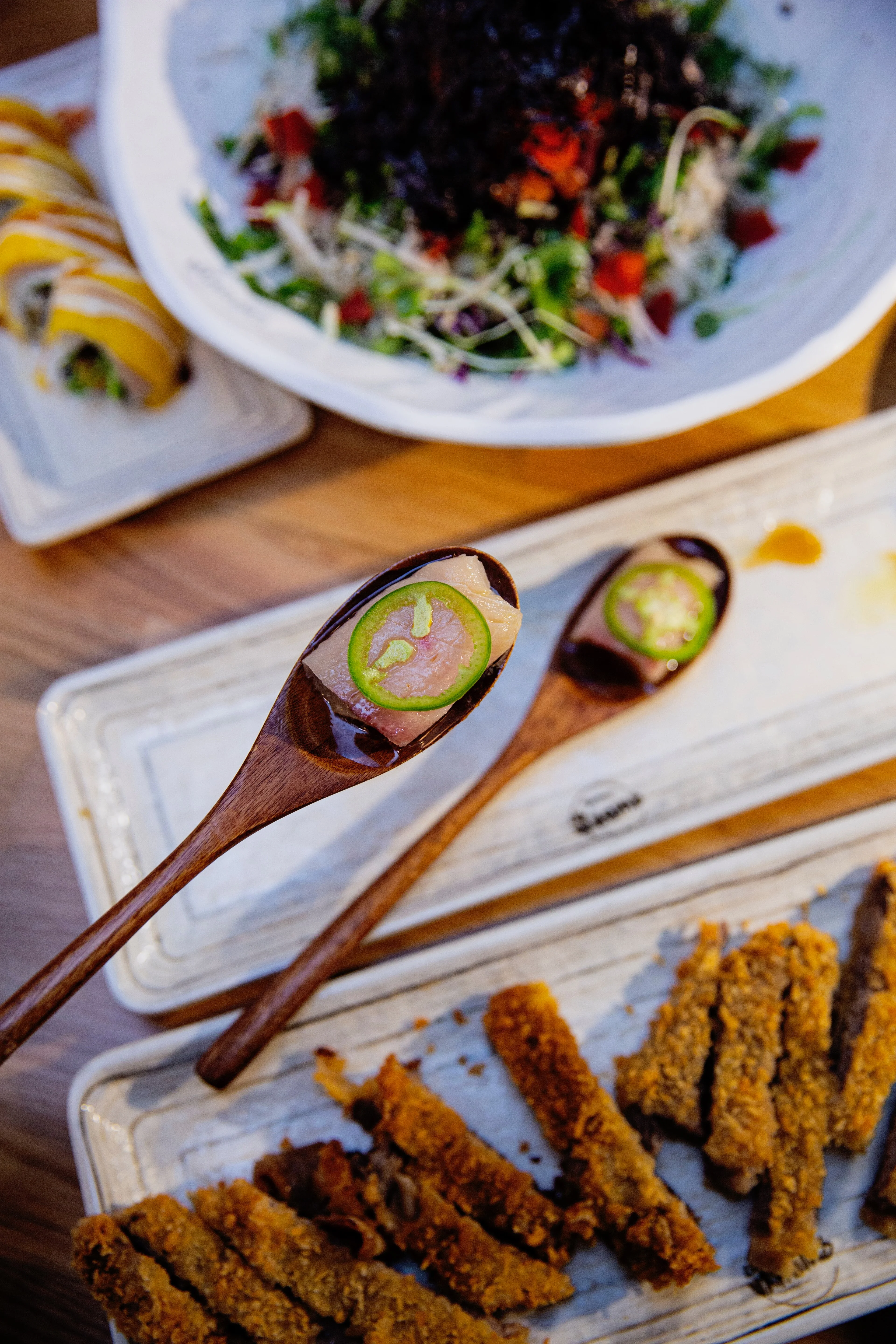 Japanese sashimi with spicy garnish on wooden spoons