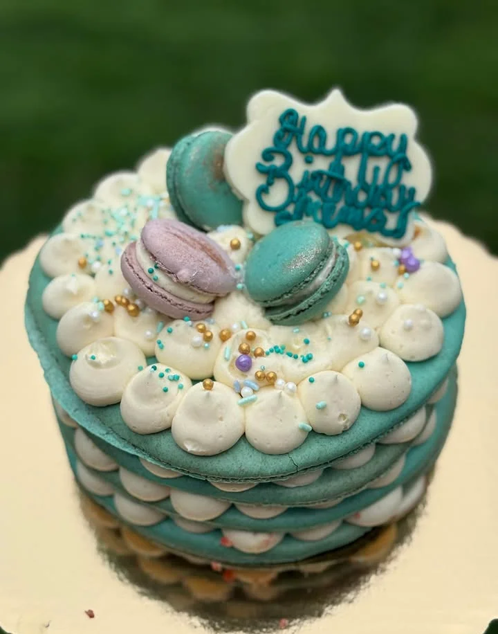 Colorful birthday cake with macarons and decorative frosting