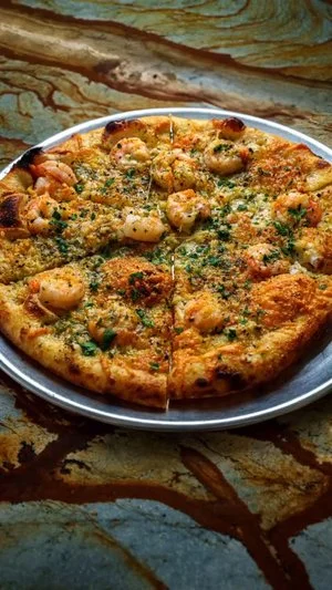 Shrimp pizza with herbs and cheese