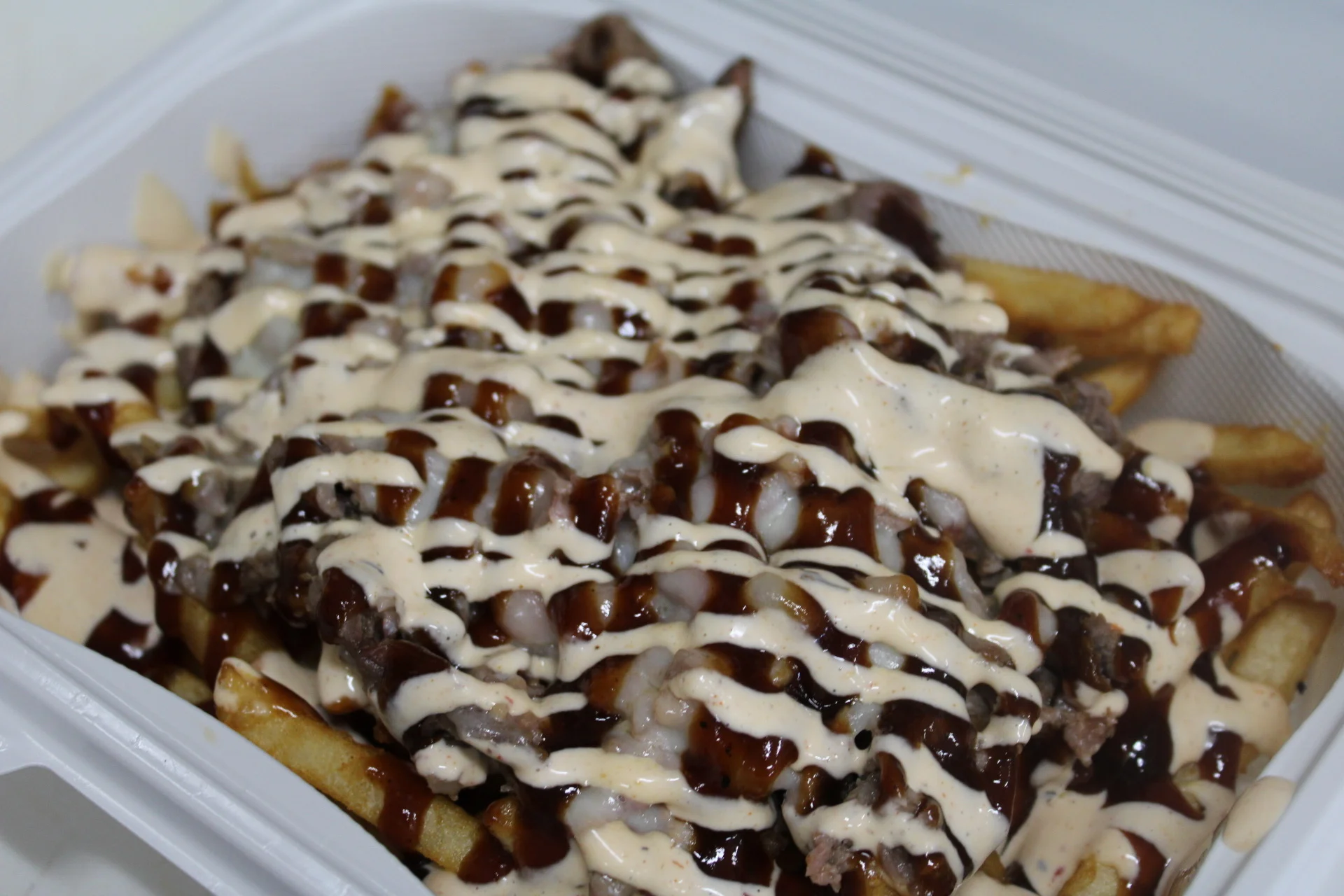 Loaded fries with barbecue sauce and creamy drizzle