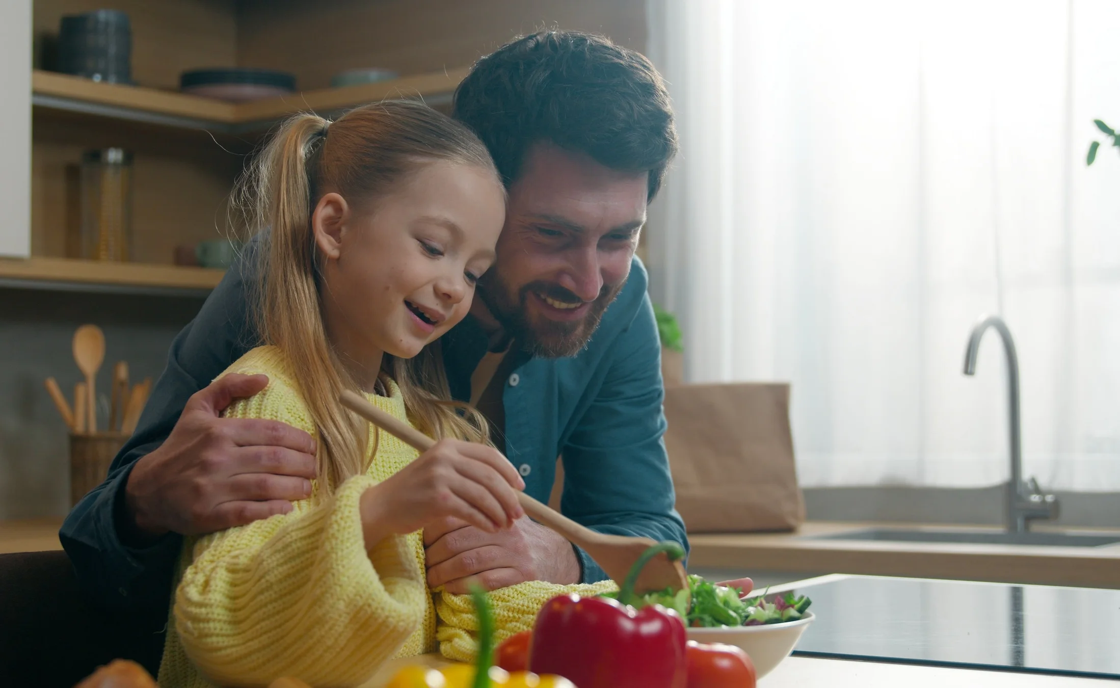 Father and daughter cooking together in a modern kitchen