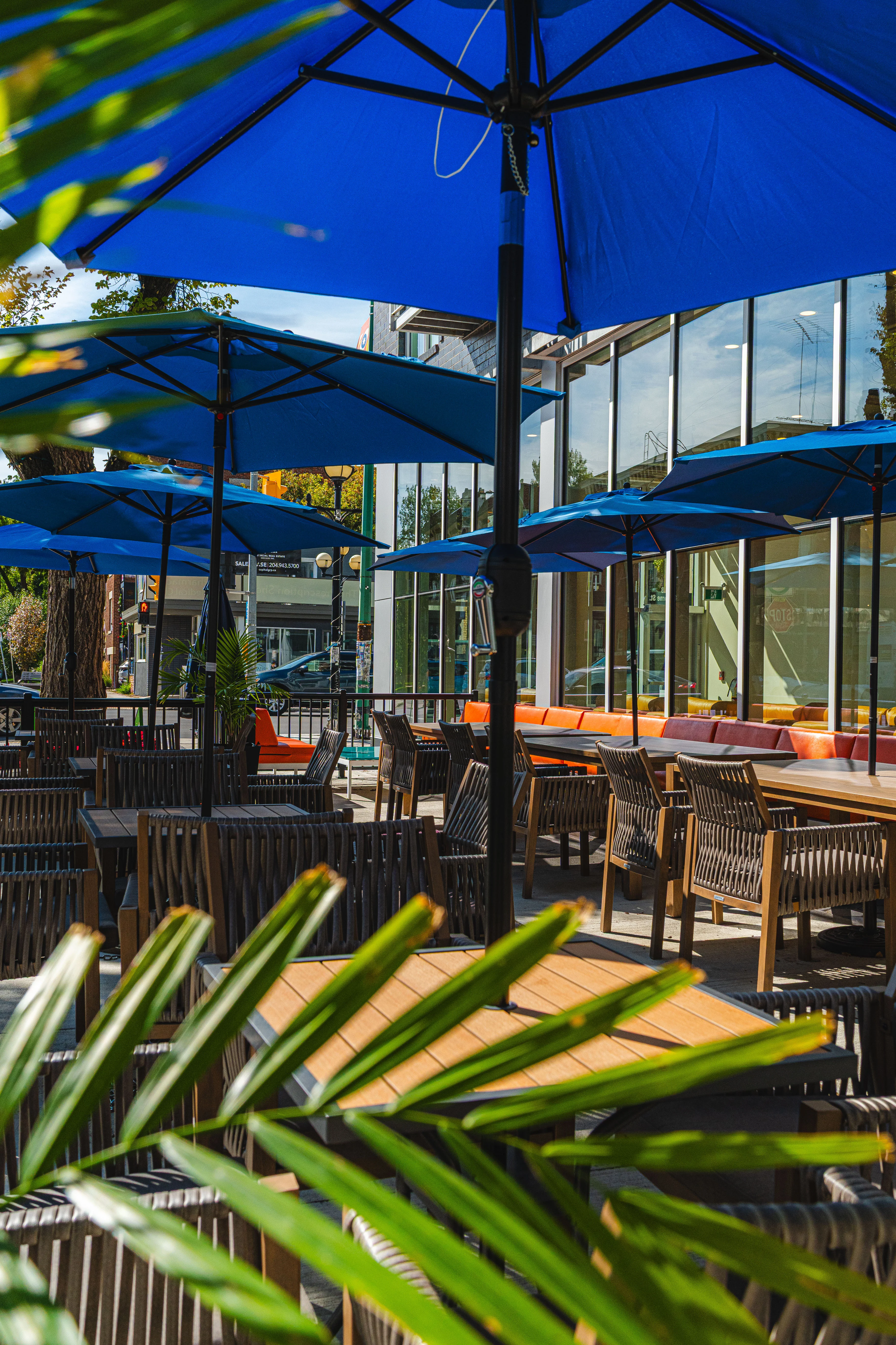 Outdoor dining area with blue umbrellas and wooden furniture