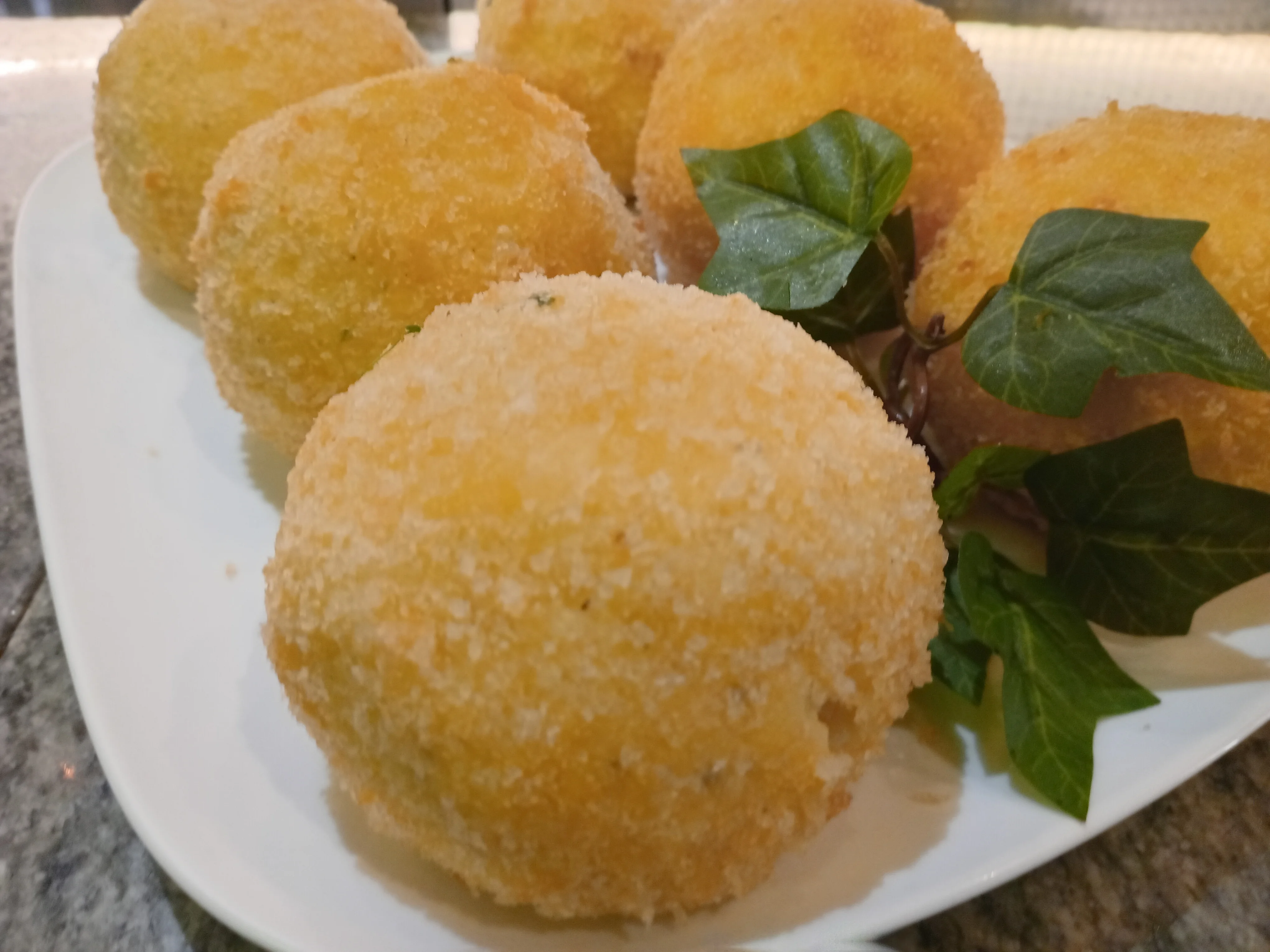 Crispy Italian arancini balls served on a platter