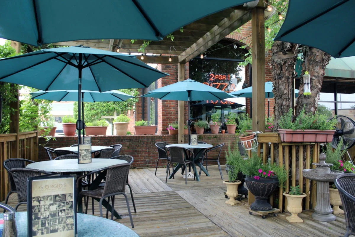 Outdoor dining area with teal umbrellas and potted plants