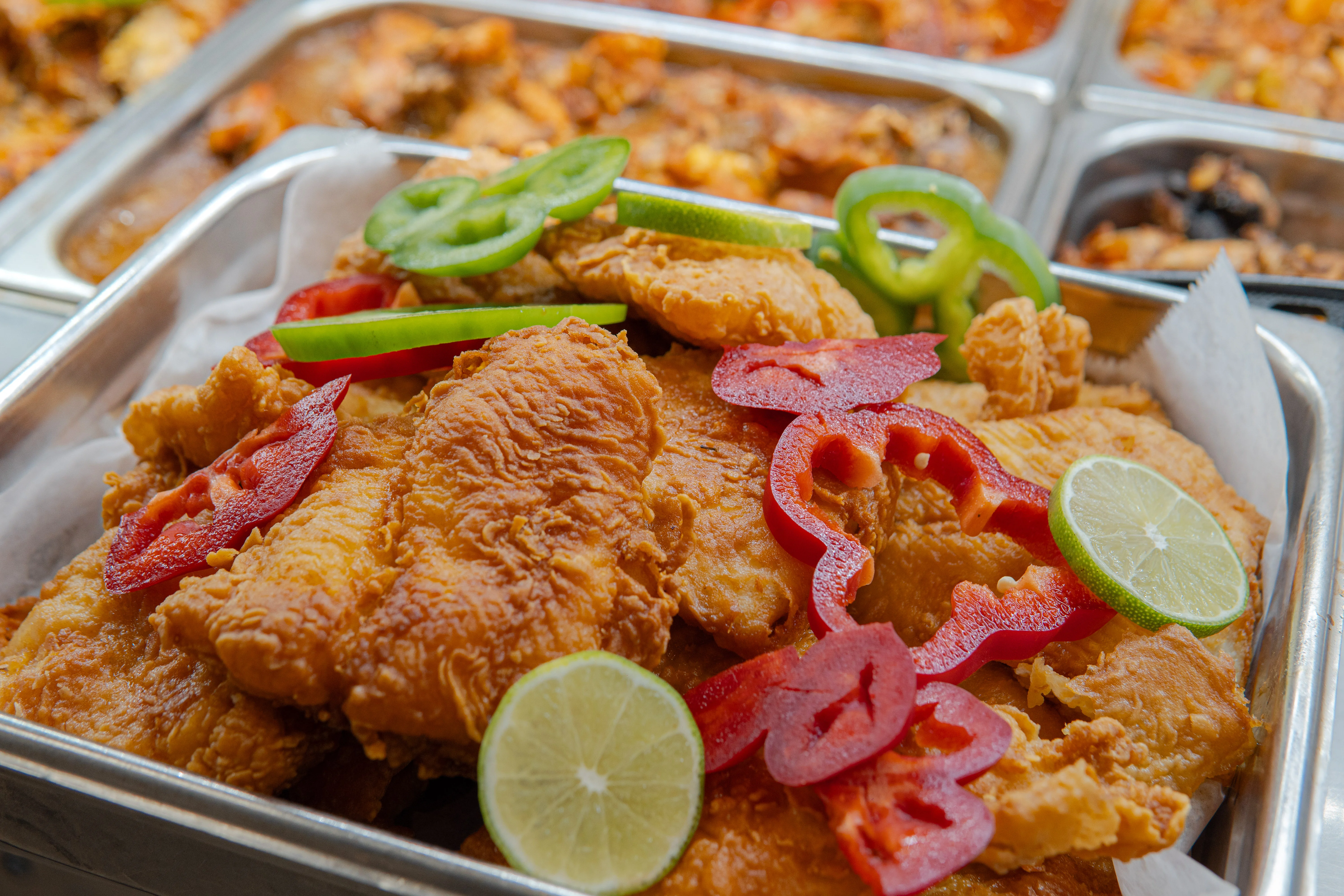 Crispy fried chicken with colorful peppers and lime garnish