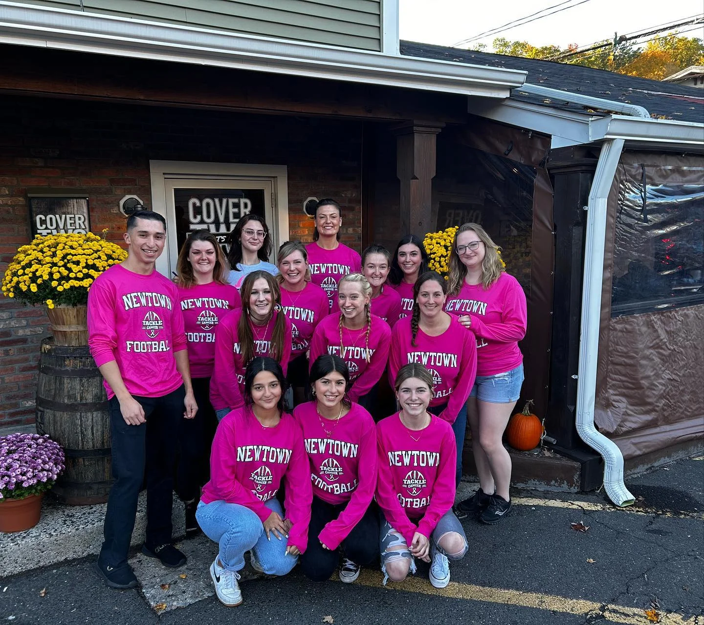 Group of supporters in pink shirts outside a restaurant