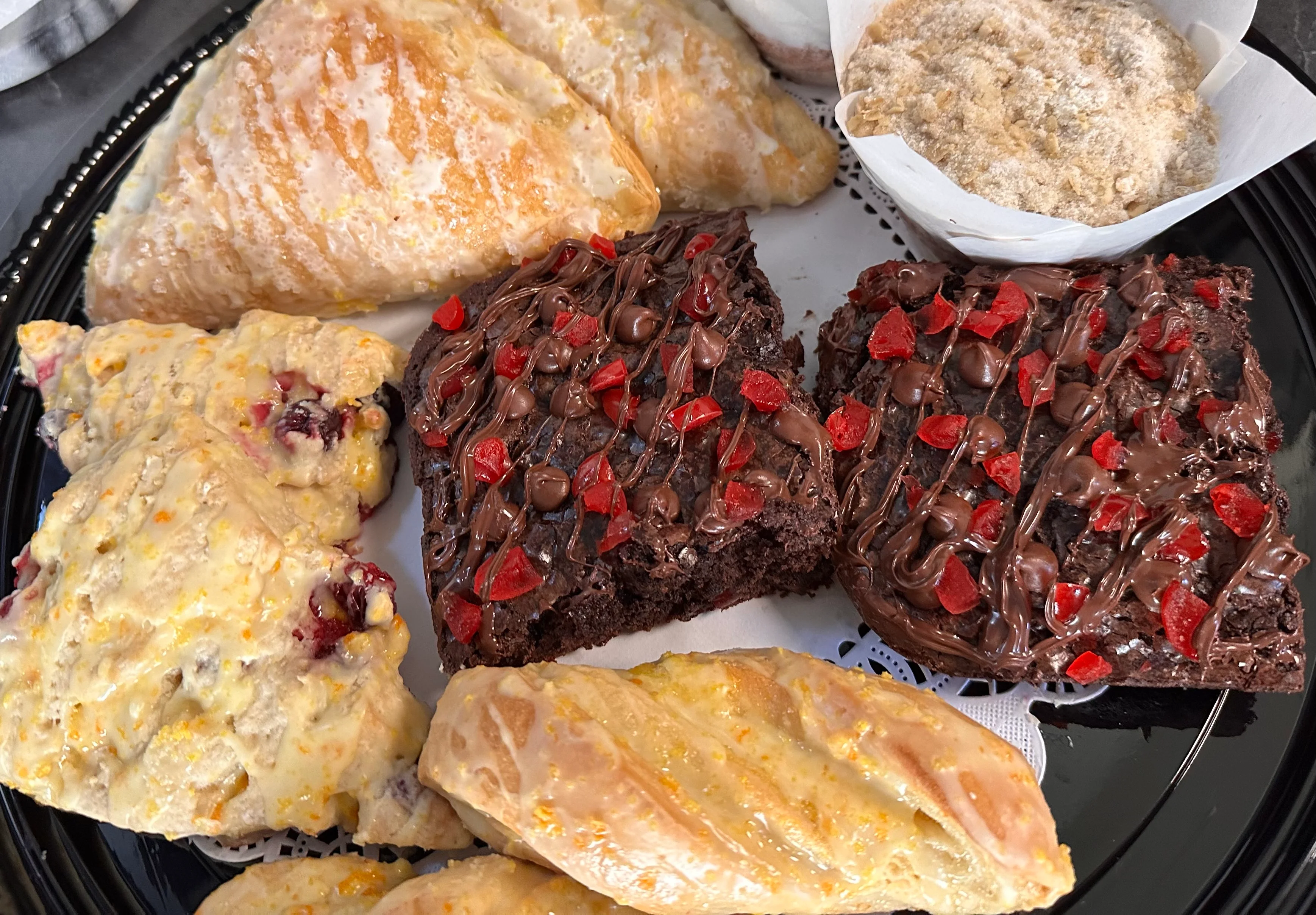 Assorted pastries including scones and brownies on a decorative platter