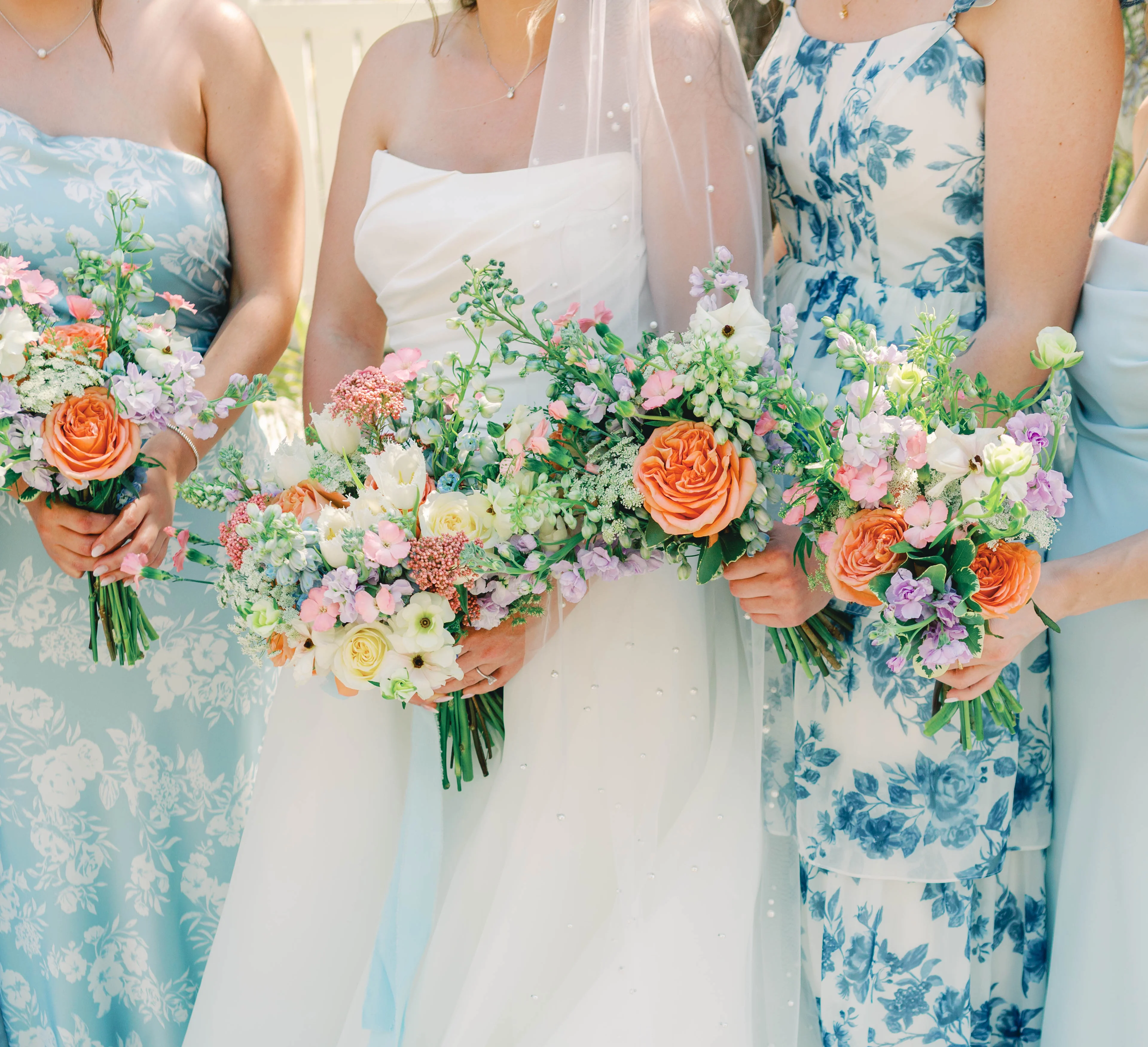 Bridesmaids holding colorful floral bouquets at a wedding