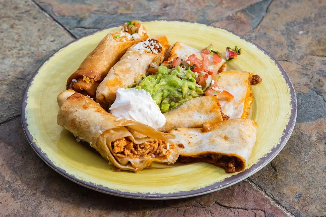 Plate of crispy Mexican flautas with guacamole and salsa