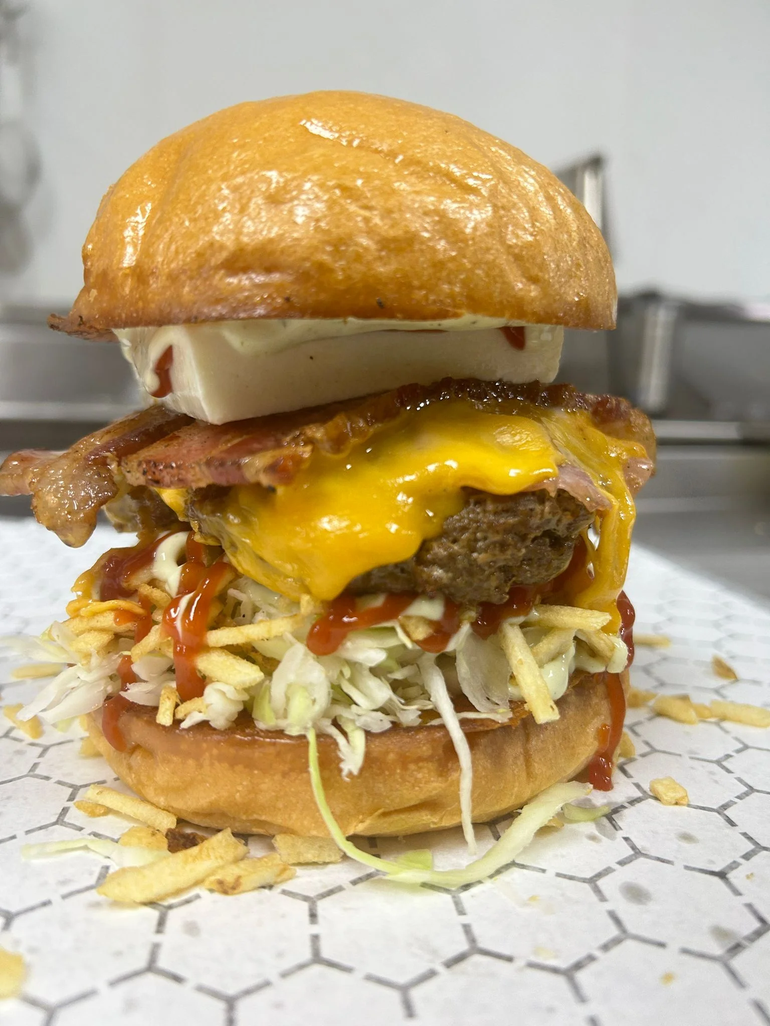 Juicy cheeseburger with bacon and coleslaw on a brioche bun