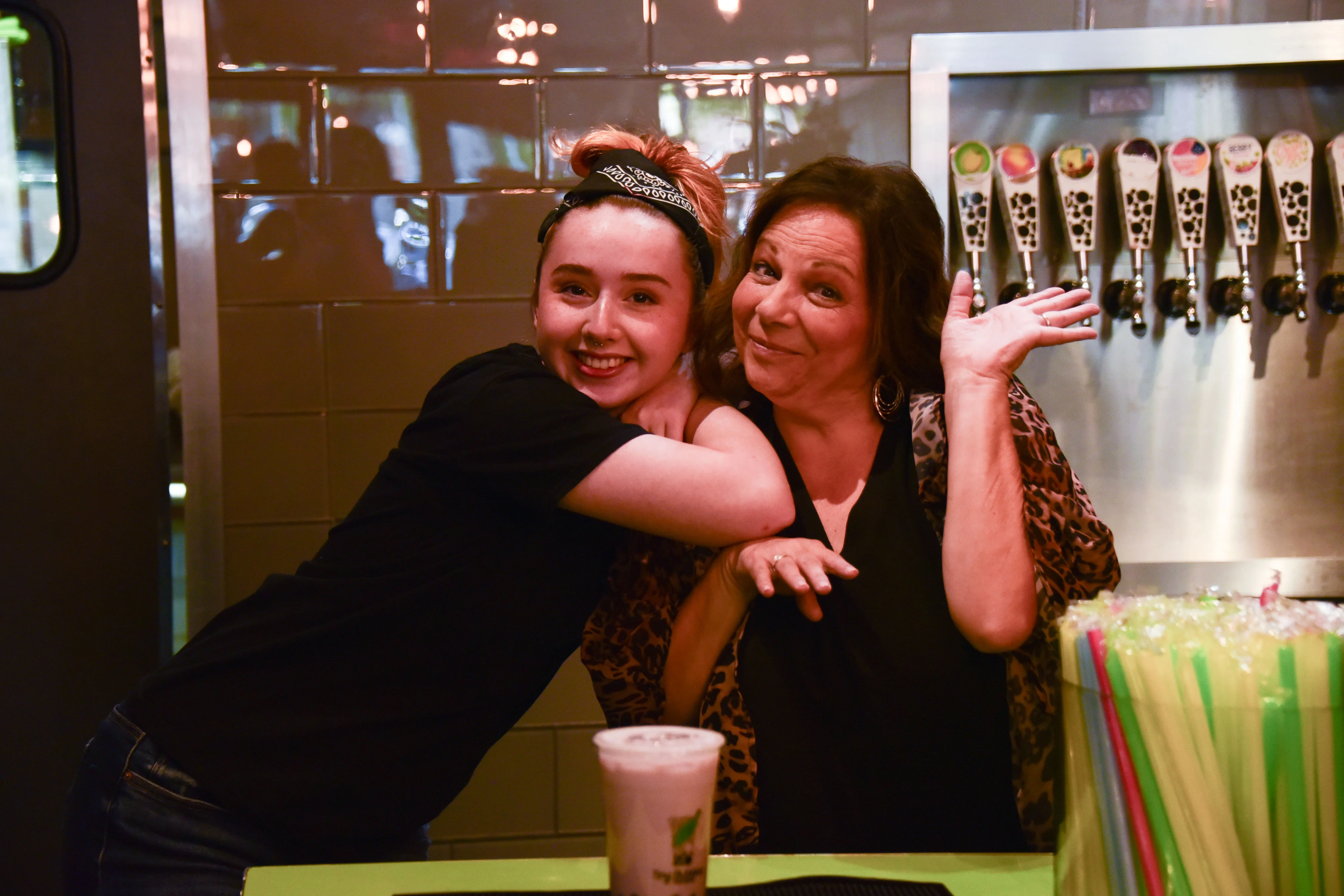 Tea on tap with various flavors being poured at a vibrant beverage bar