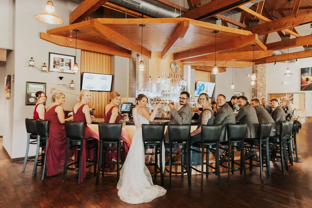 A wedding party smiling at the Driftless Glen bar