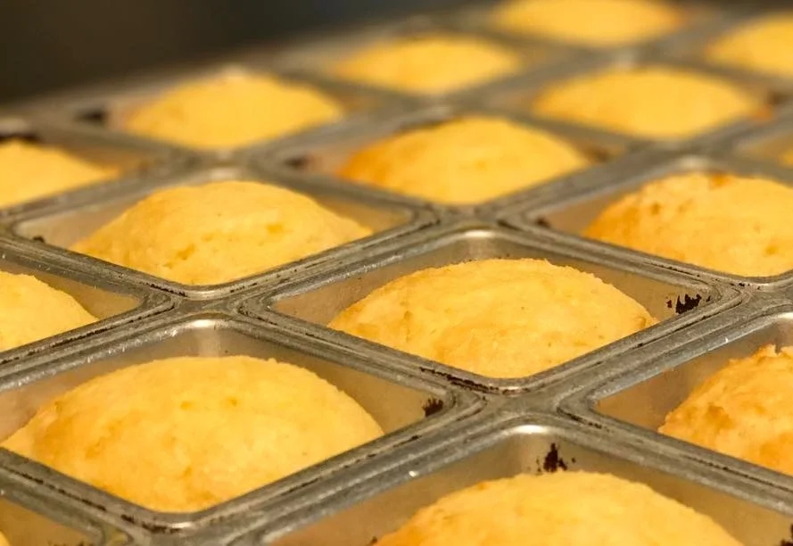 Fresh-baked cornbread muffins from VooDoo BBQ in Pensacola, golden and lightly sweet, served as a signature side.
