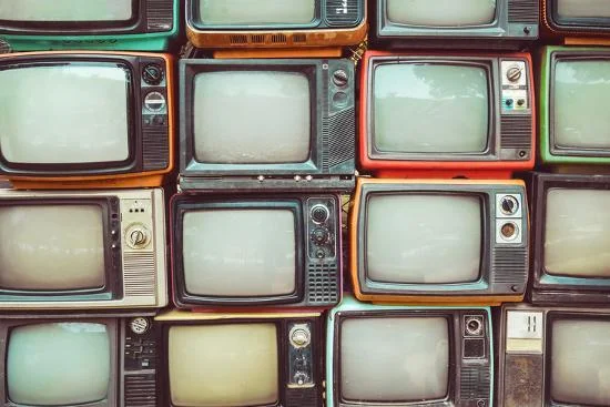 Collection of vintage televisions stacked together