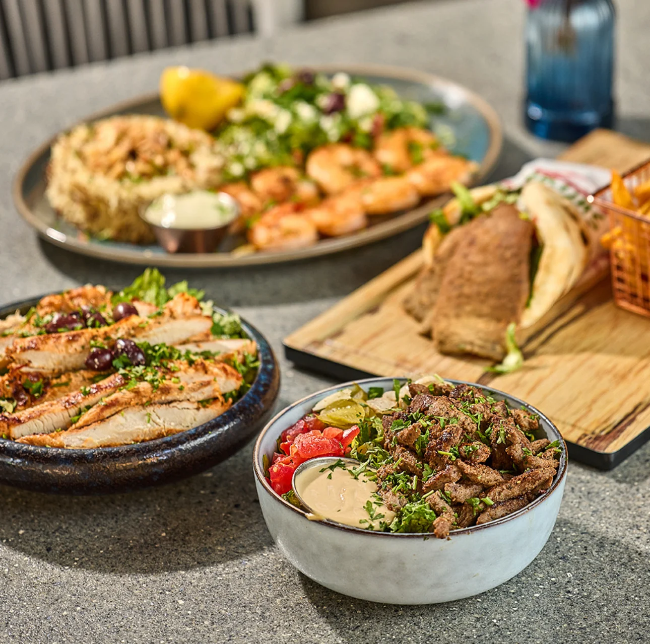 Mediterranean dishes served on a table with grilled meats, fresh salad, pita bread, and traditional sides.