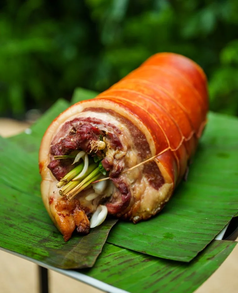 Filipino lechon belly with herbs wrapped in banana leaves