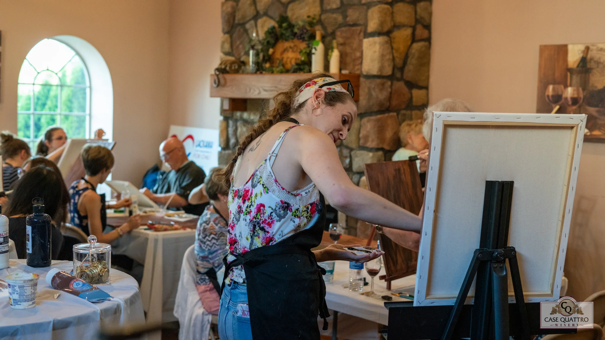 Art class in a cozy winery setting with participants painting