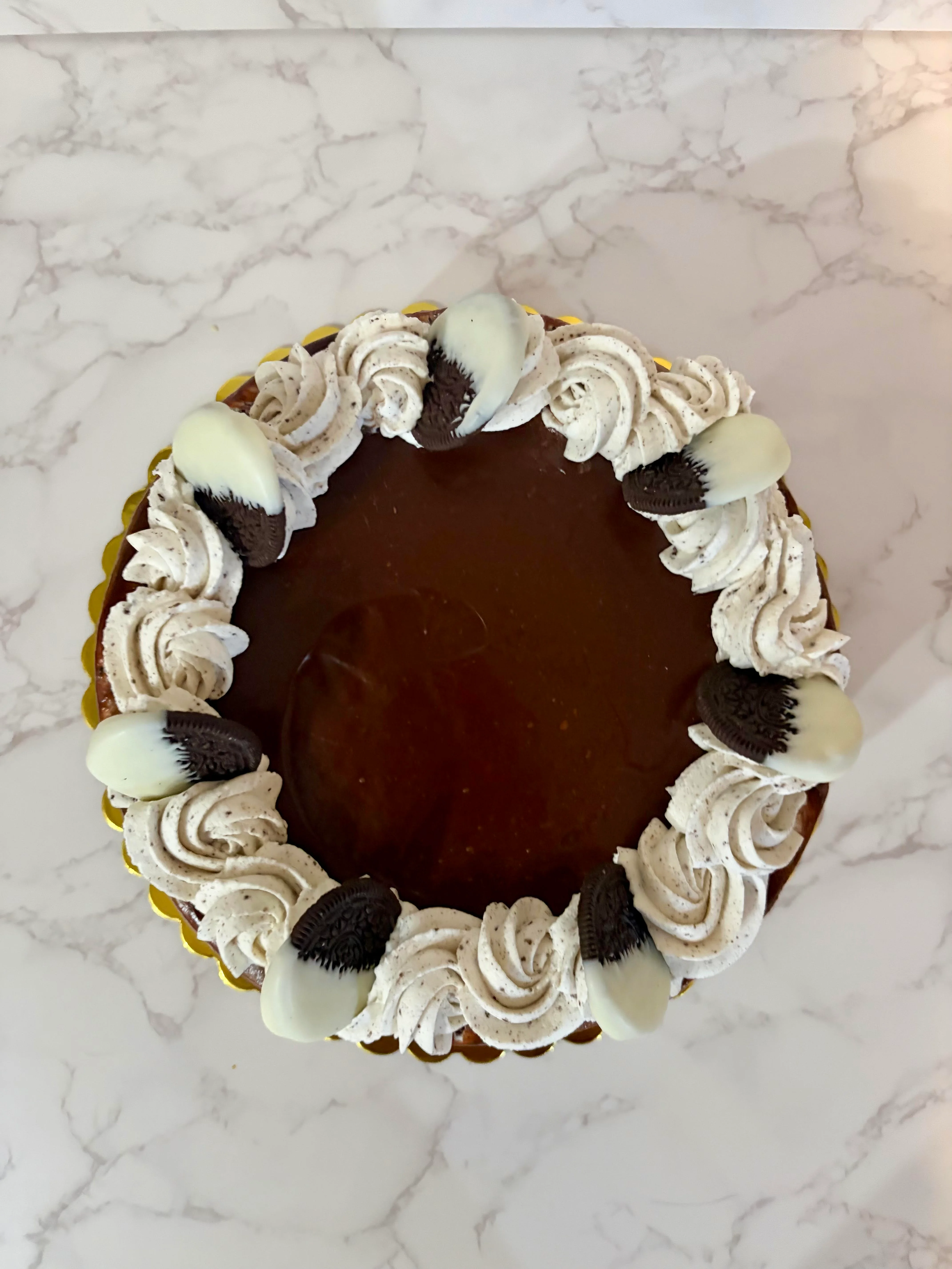 Chocolate cake topped with whipped cream and Oreo cookies.