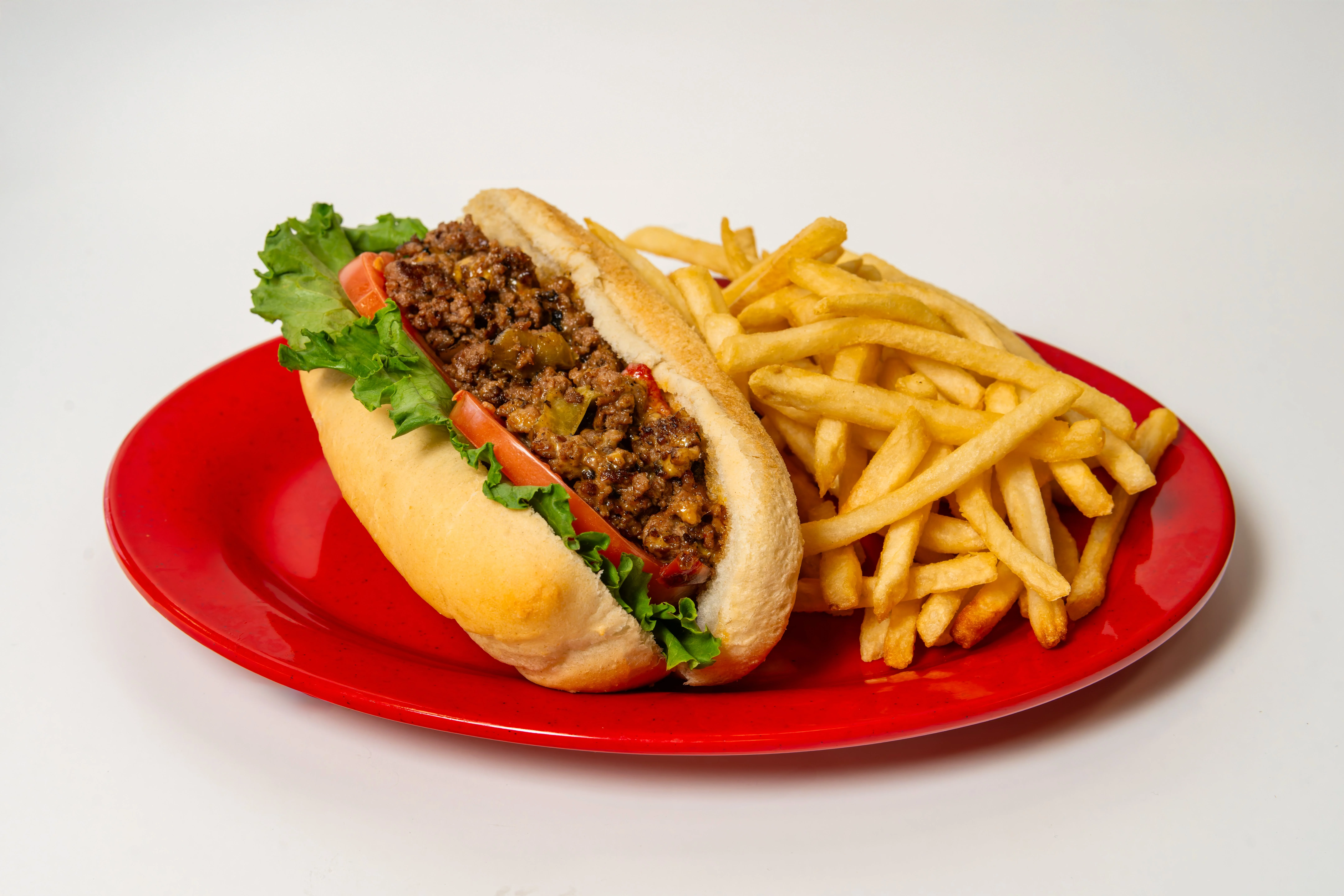 Classic American chili dog with fries on a red plate