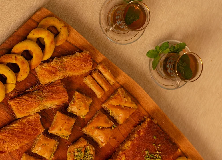Assorted Middle Eastern sweets with mint tea on a wooden platter