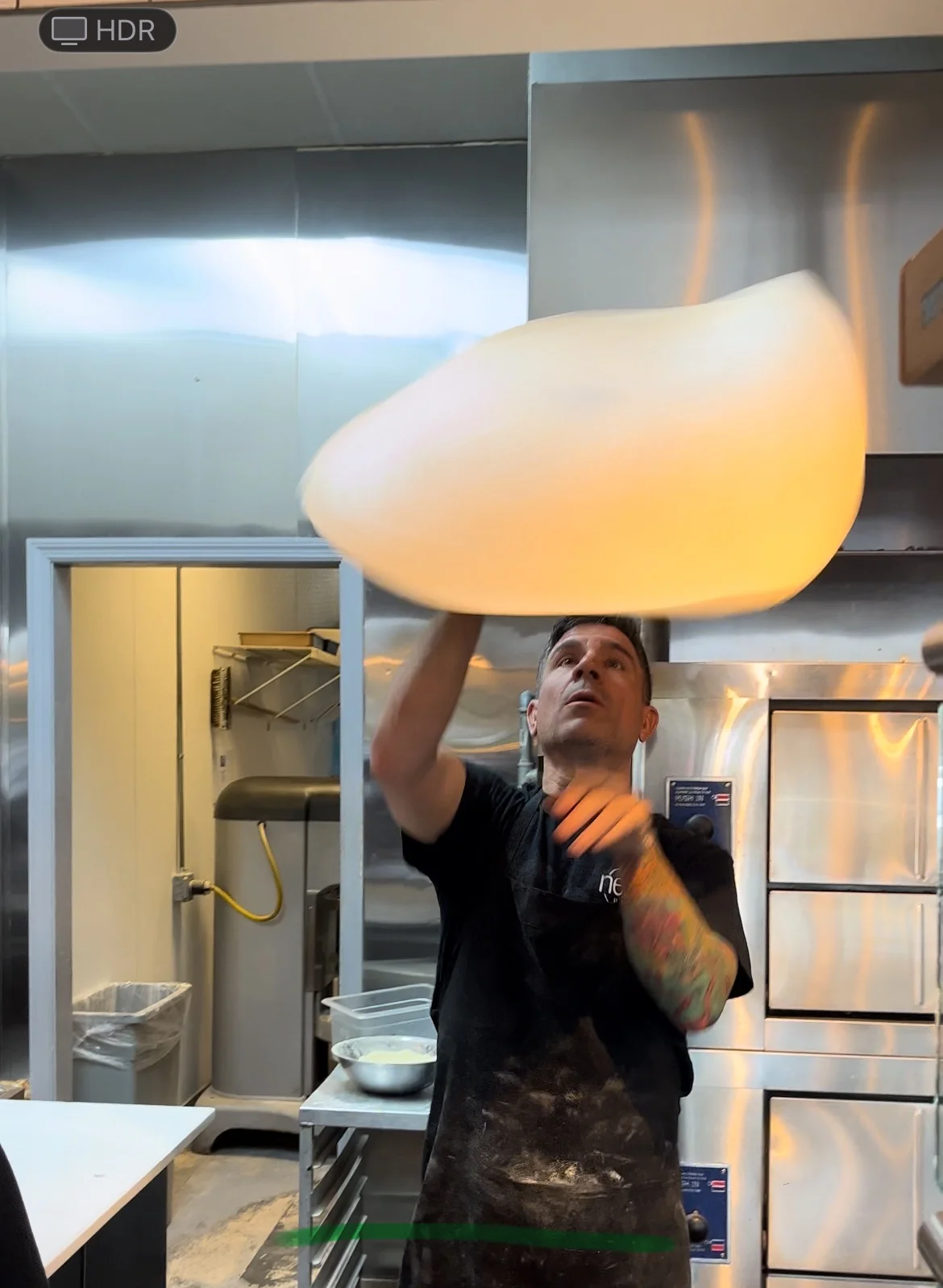 Chef tossing pizza dough in a modern kitchen