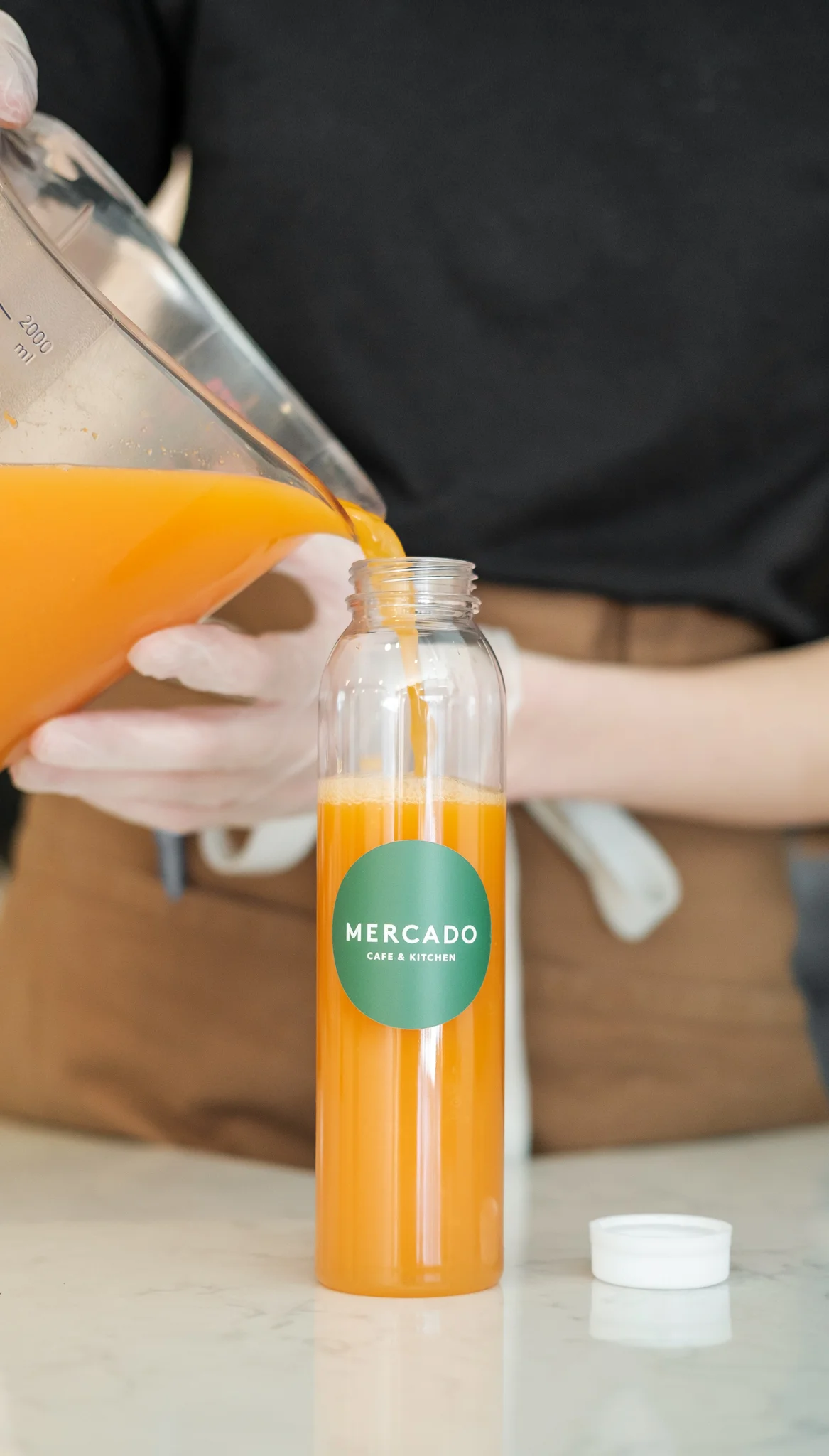 Freshly poured orange juice in a glass bottle at Mercado Cafe