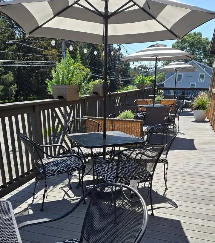 Outdoor dining area with black and white patterned chairs and umbrellas.