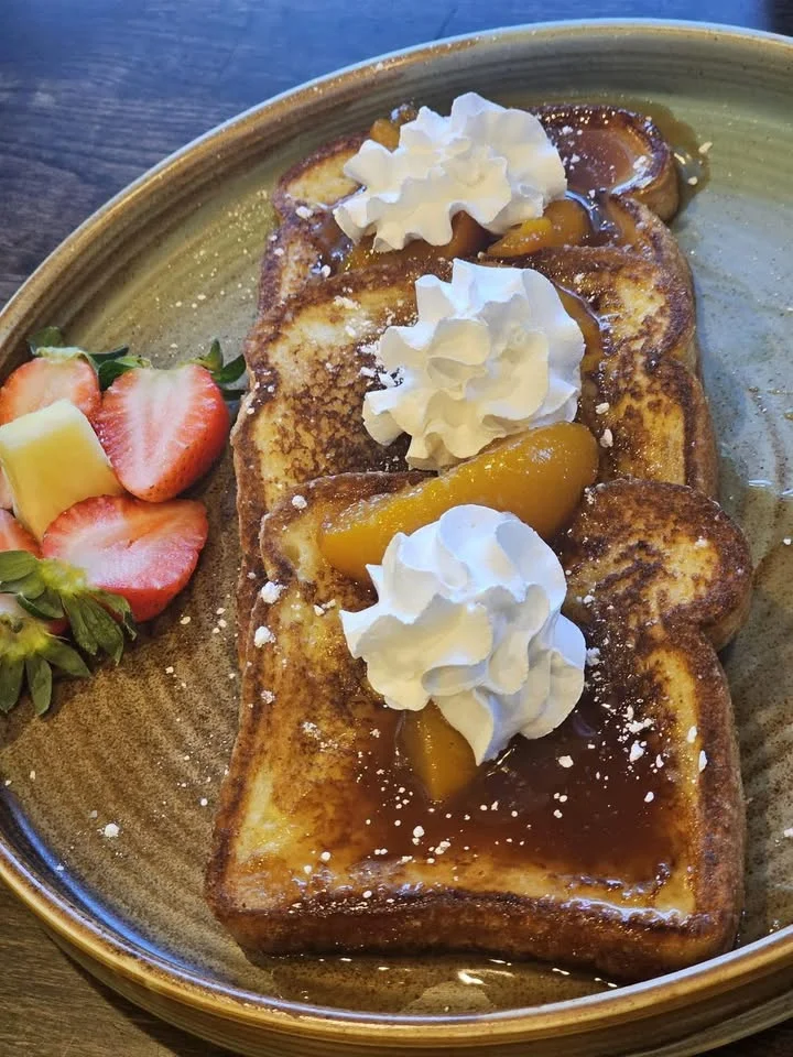French toast topped with peaches and whipped cream
