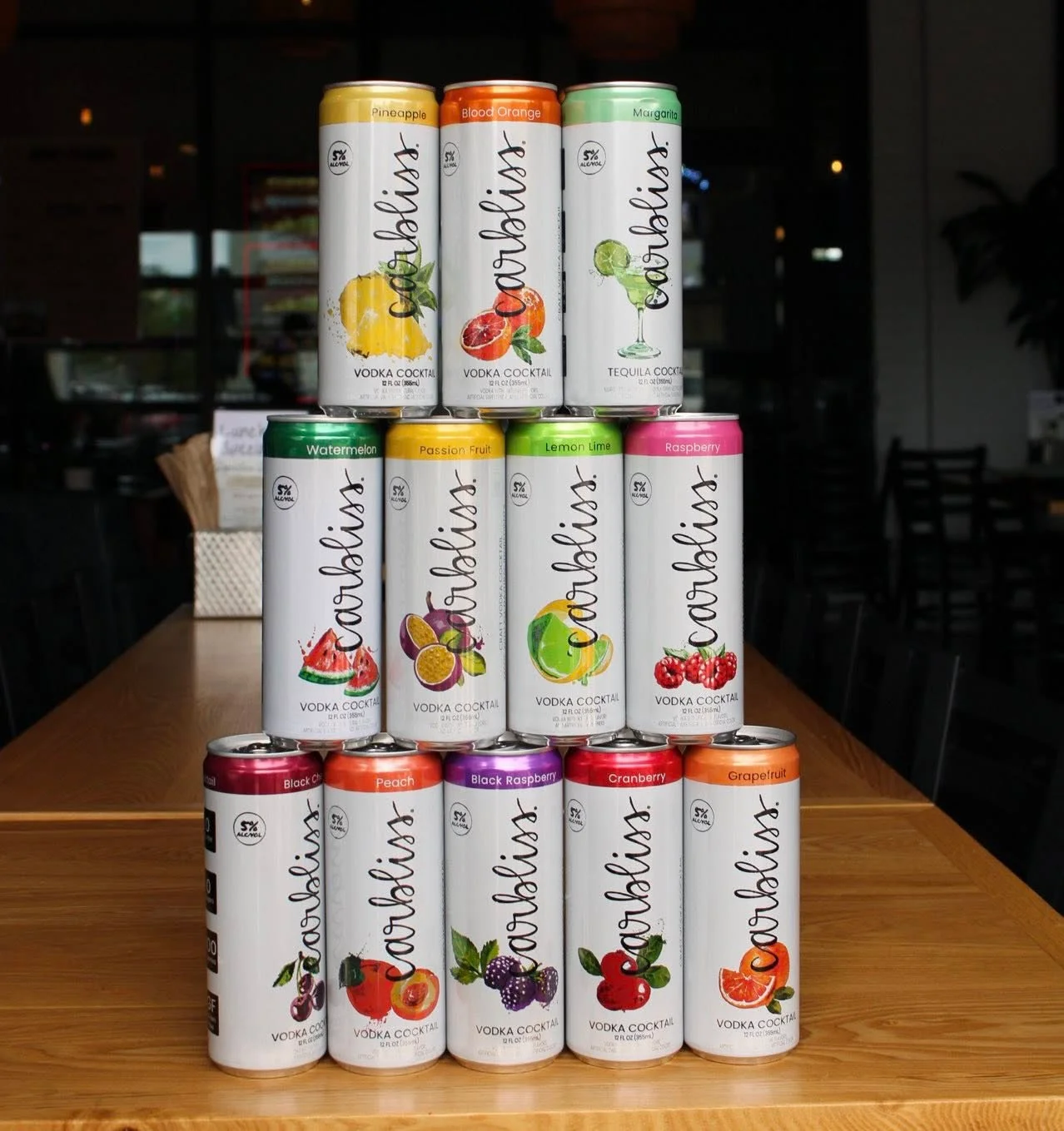 Variety of canned vodka cocktails stacked on a wooden table